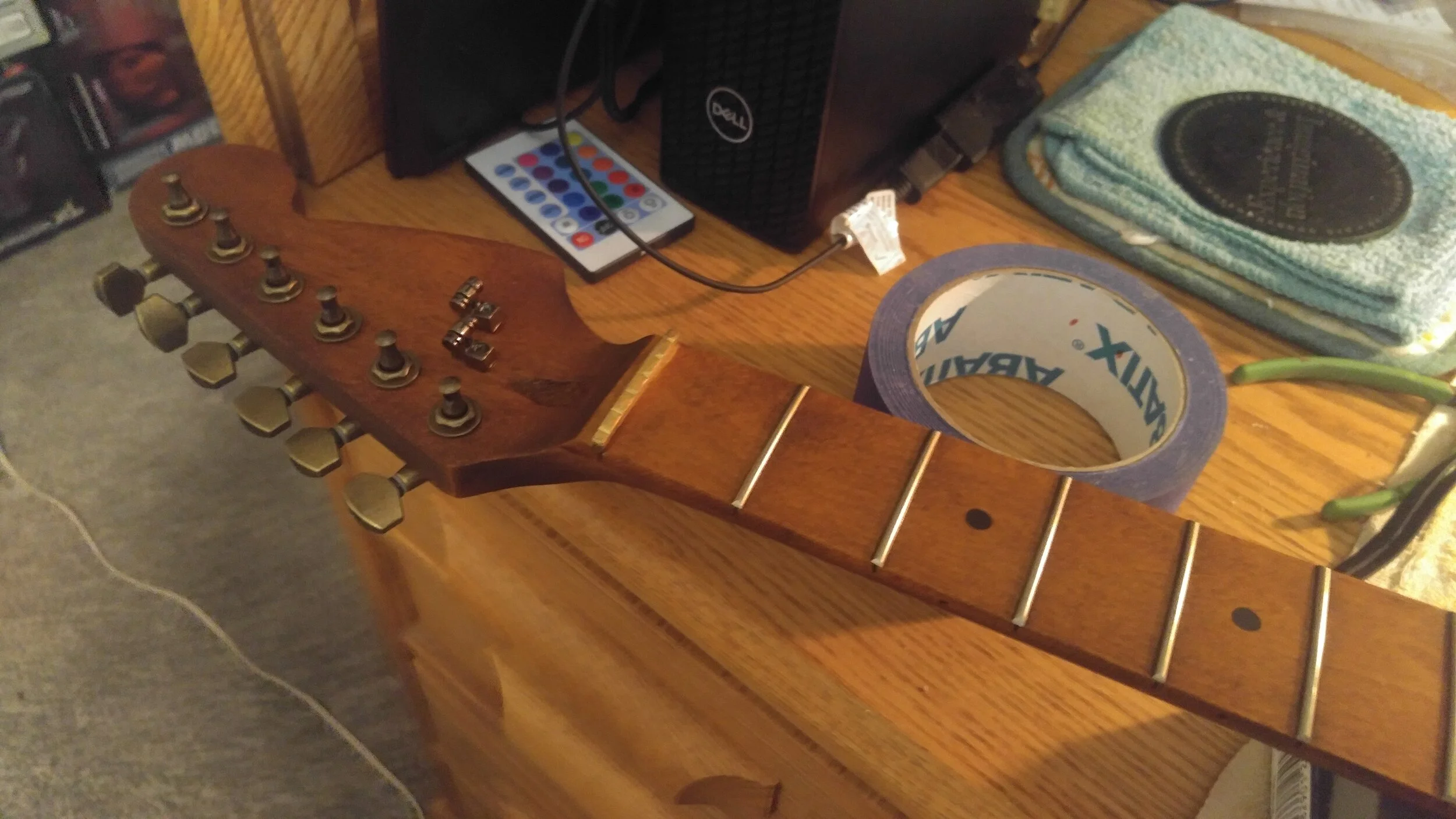 Closeup of headstock, with brass nut installed.  As well as aged brass tuners.