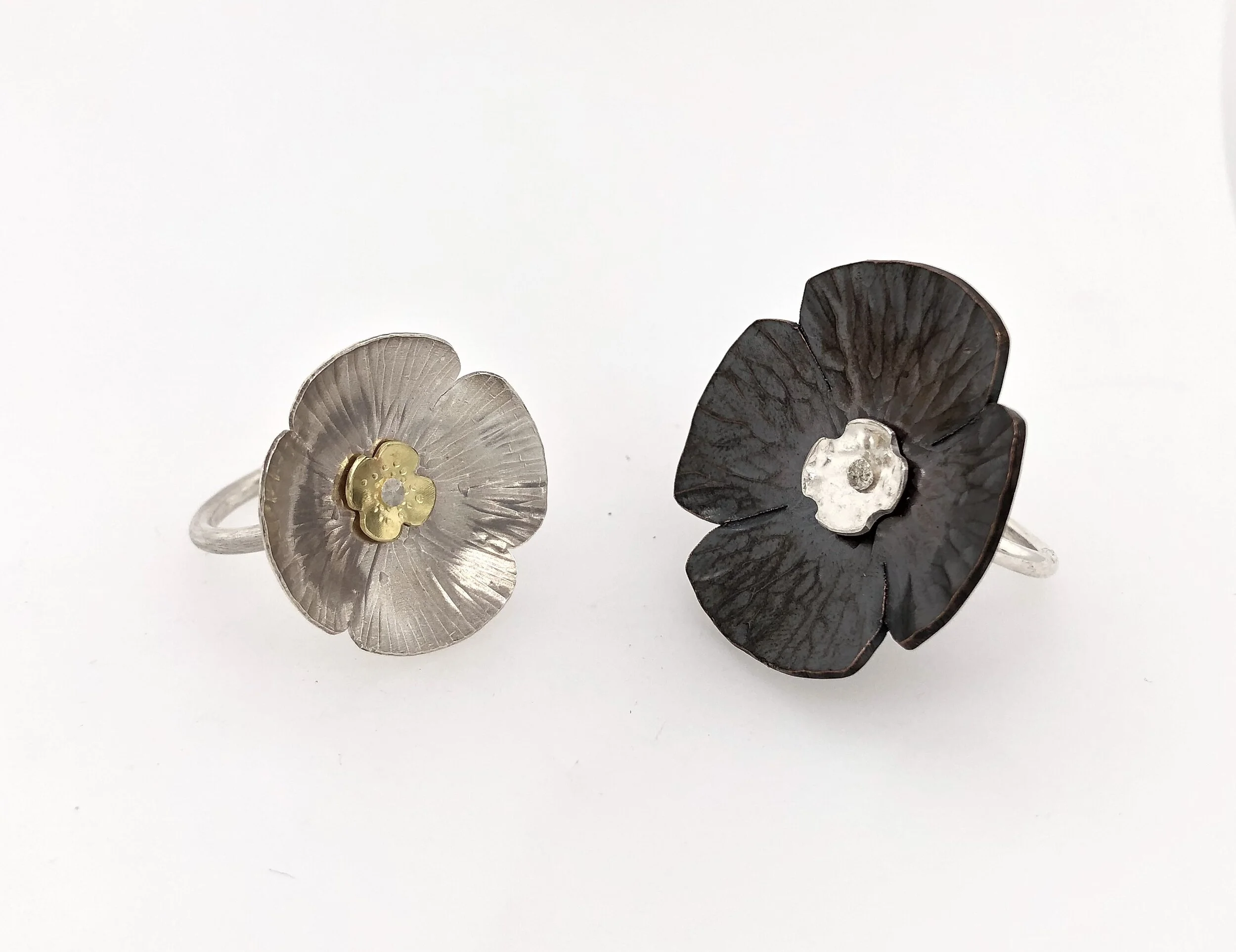  Hand forged flowers riveted to a sterling silver band. One is silver and gold; the other is copper and silver. 