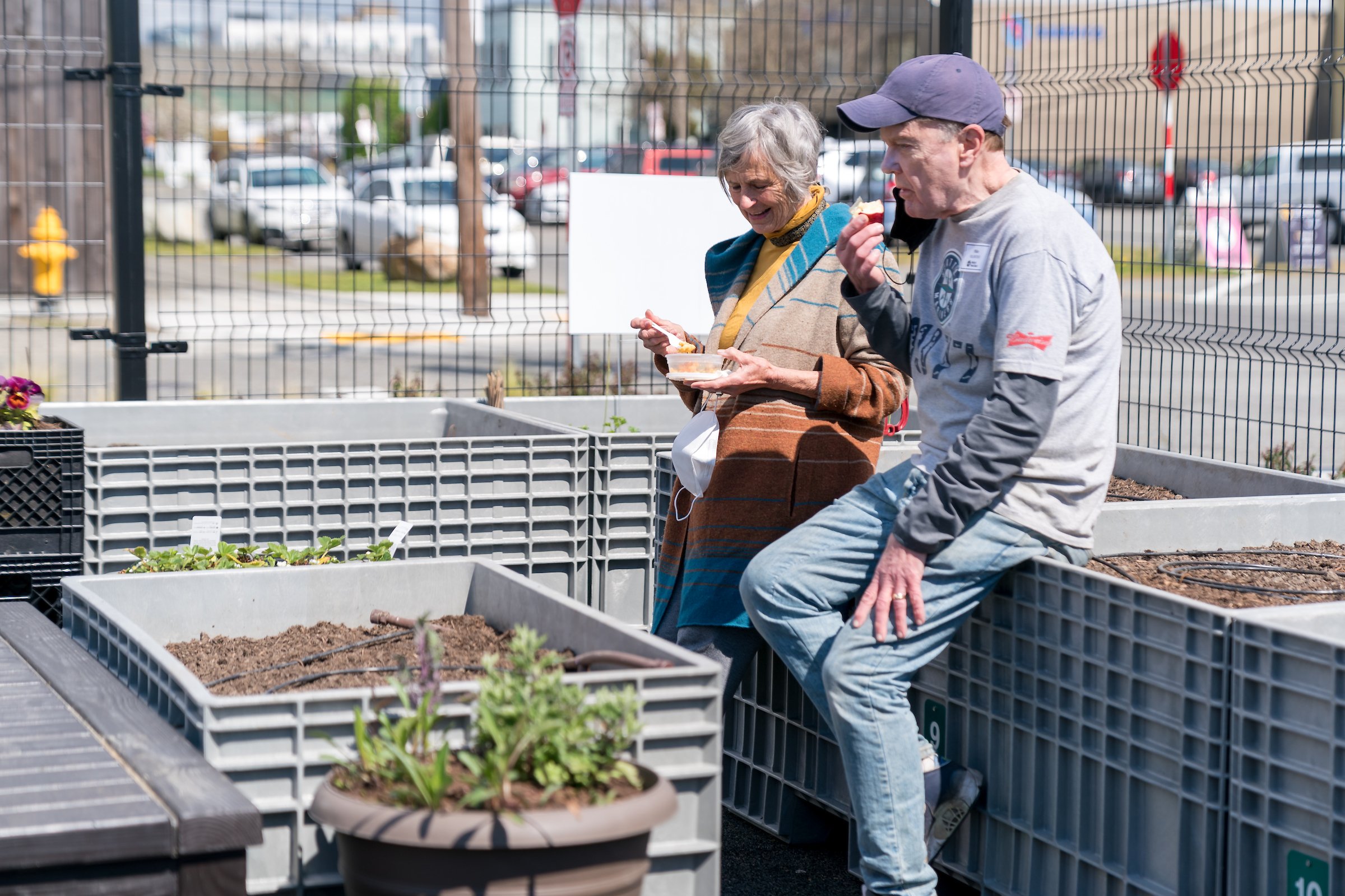 Voluntarios sentados comiendo en el jardín Ballard Food Bank .jpg