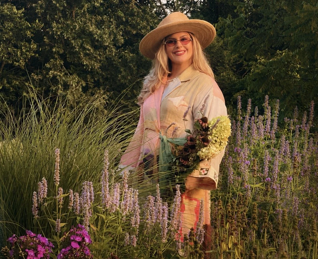 Clare Horne, garden and landscape designer and founder of The Grass Girl, gathering flowers in her Middle Tennessee meadow at golden hour.