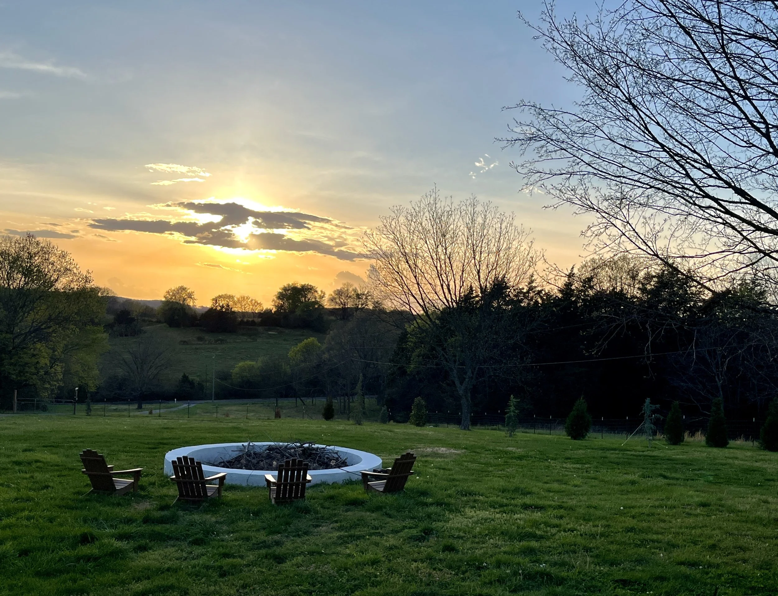 Fire pit seating at sunset on a Tennessee farm landscape