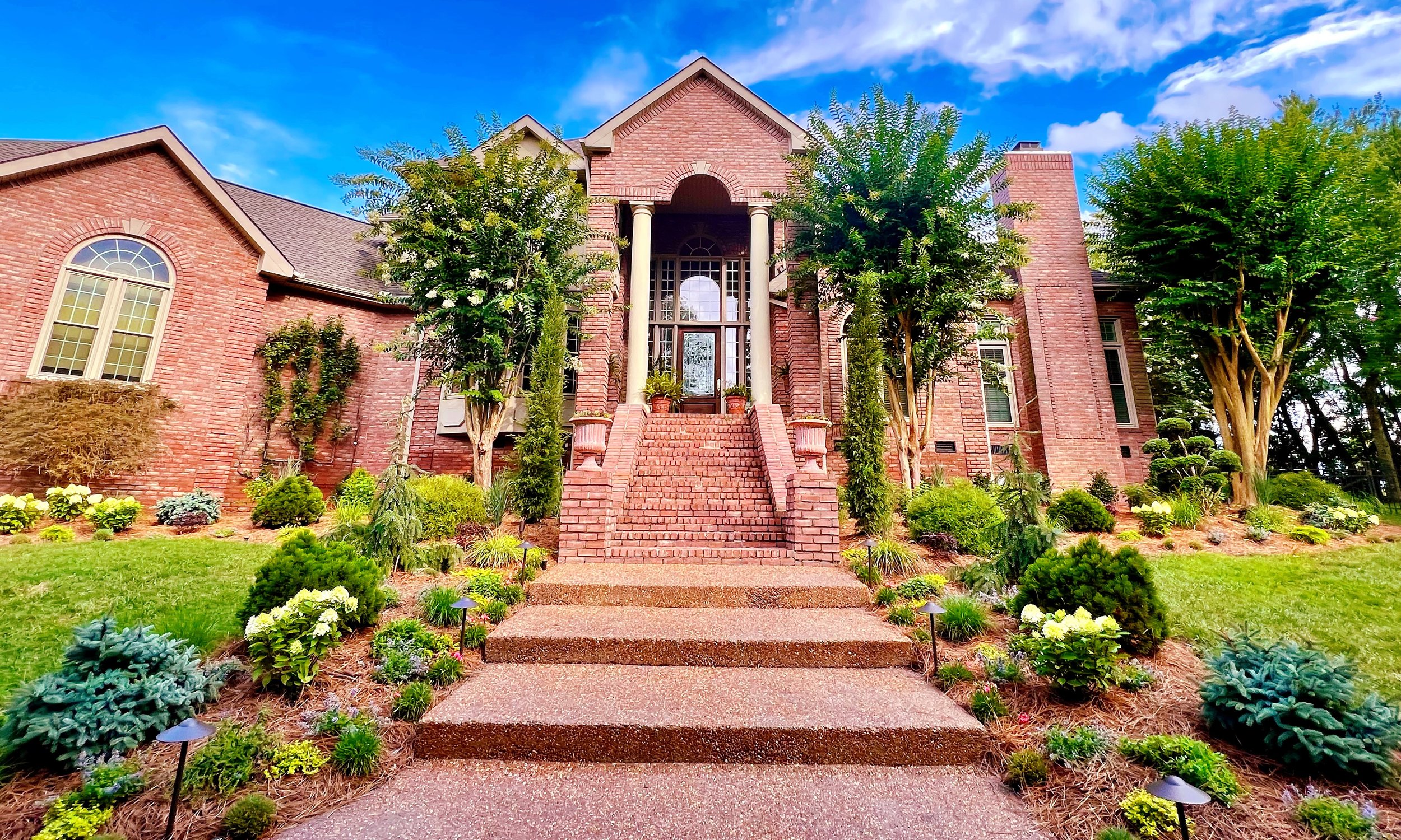 A Wilson County front entry with colorful perennials, conifers, and specimen trees.
