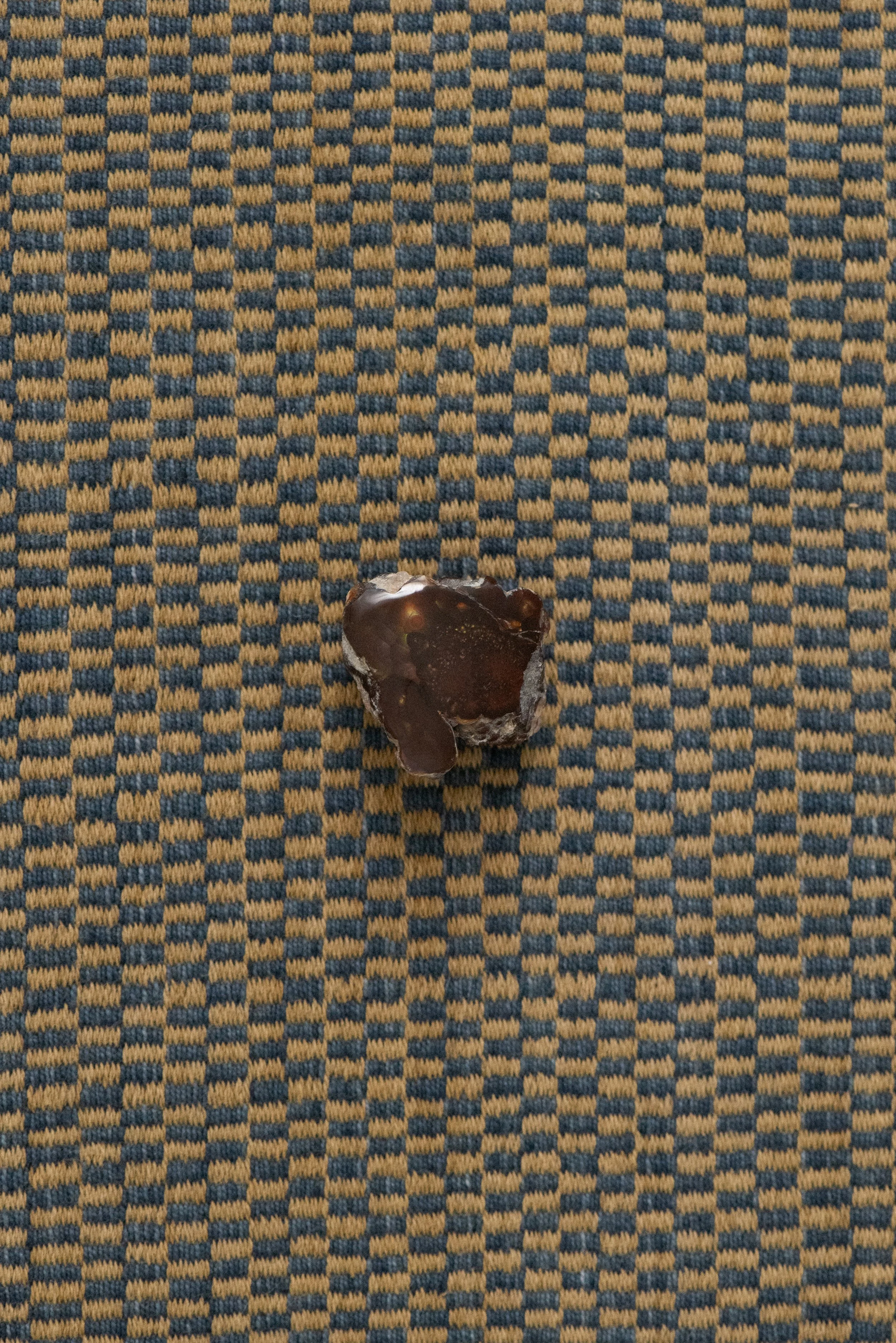 Natural fire agate crystal photographed on patterned textile, Agua Caliente Mexico