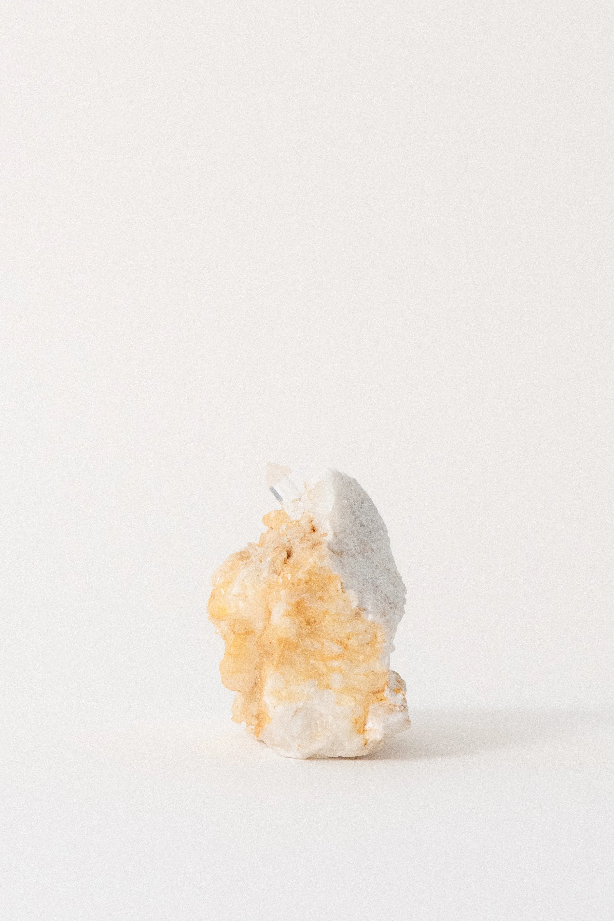 Upright profile of quartz crystal on Carrara marble from La Facciata Quarry in Italy, showing vertical structure and golden matrix detail, photographed for Crystal Voyager.
