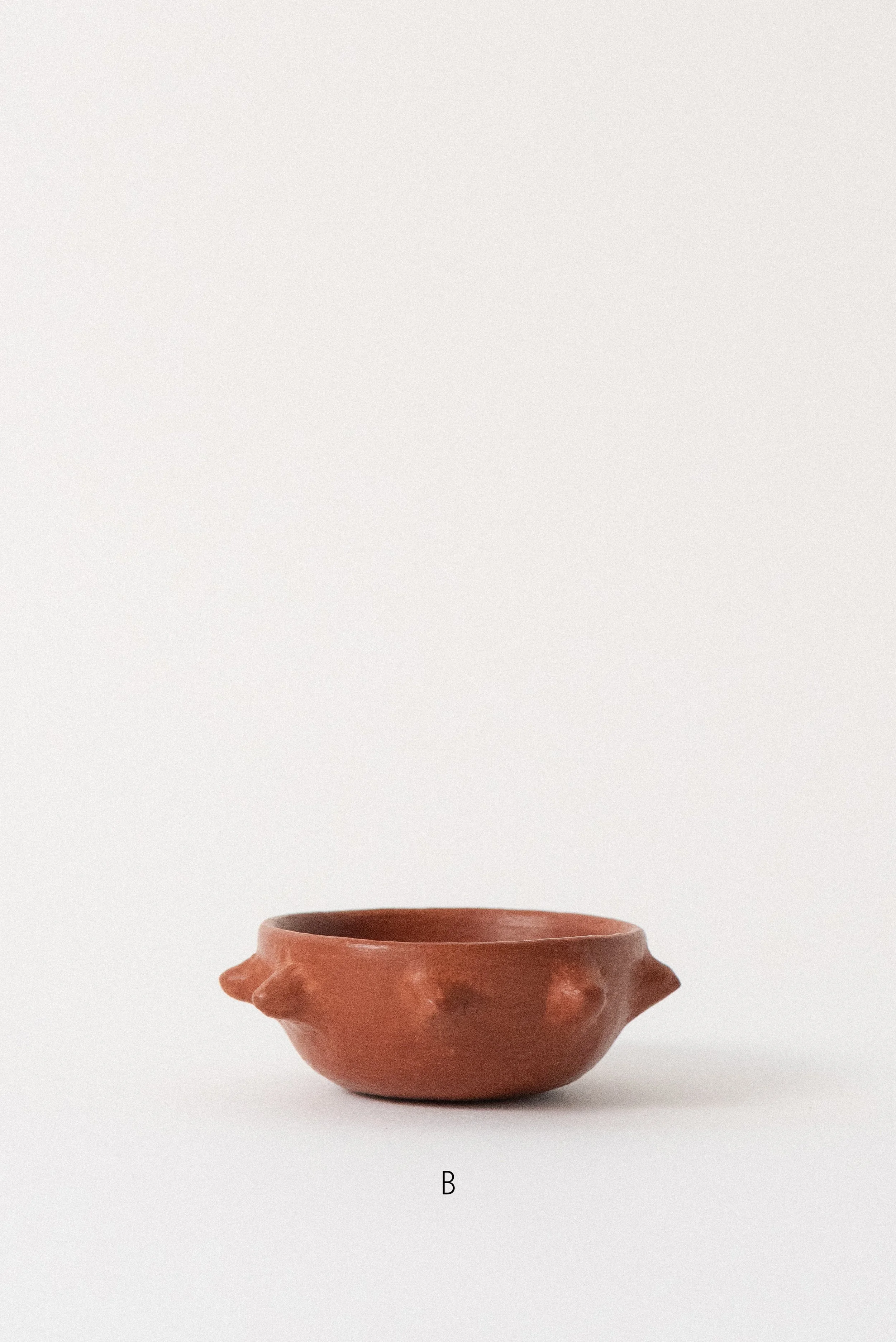 Close-up of a single red clay spiked bowl, handmade in Oaxaca using traditional Zapotec pottery methods.
