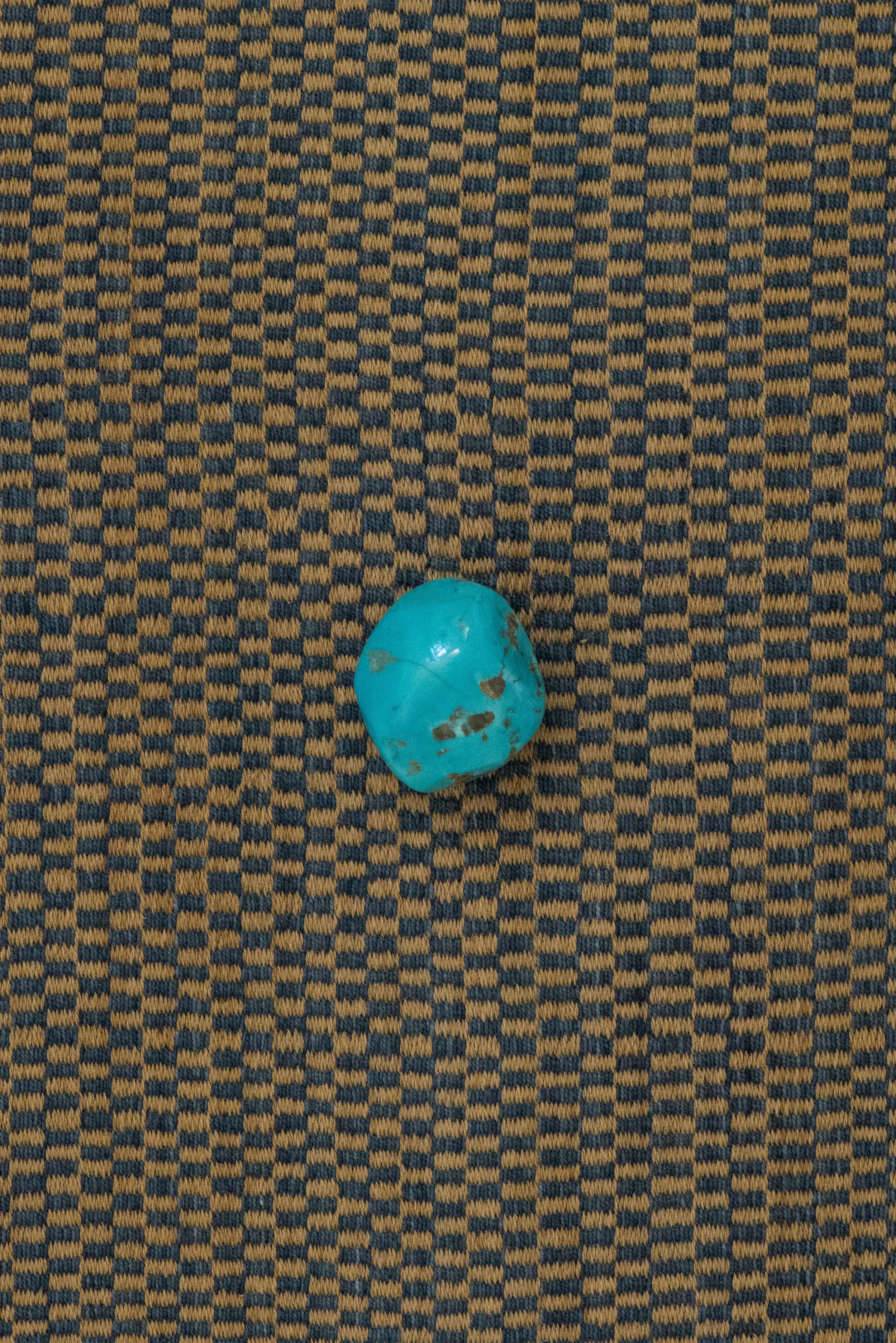Polished Egyptian turquoise stone from Sinai with vivid blue-green color and natural brown inclusions.