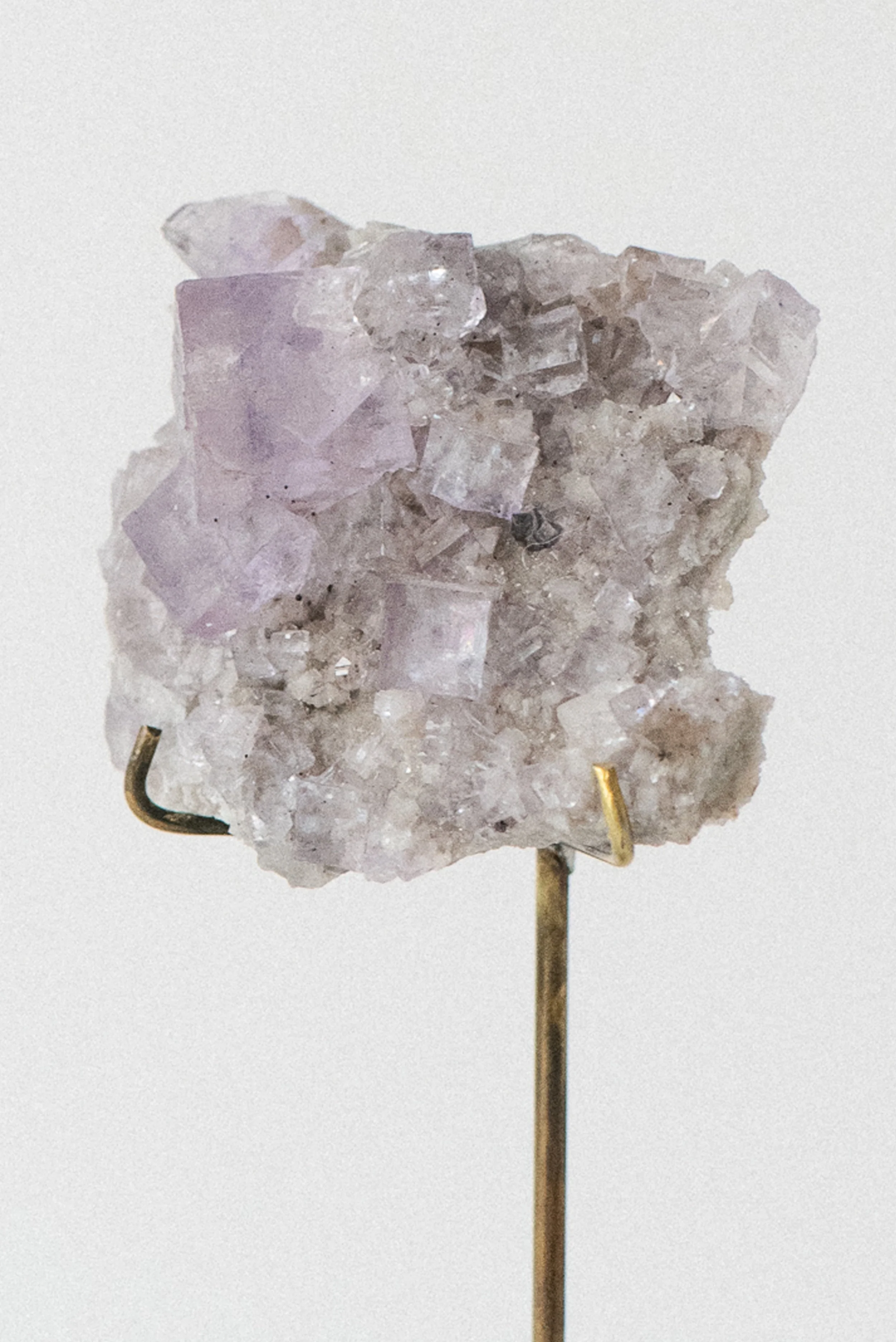 Close-up of handmade patinaed brass stand supporting Tennessee fluorite specimen