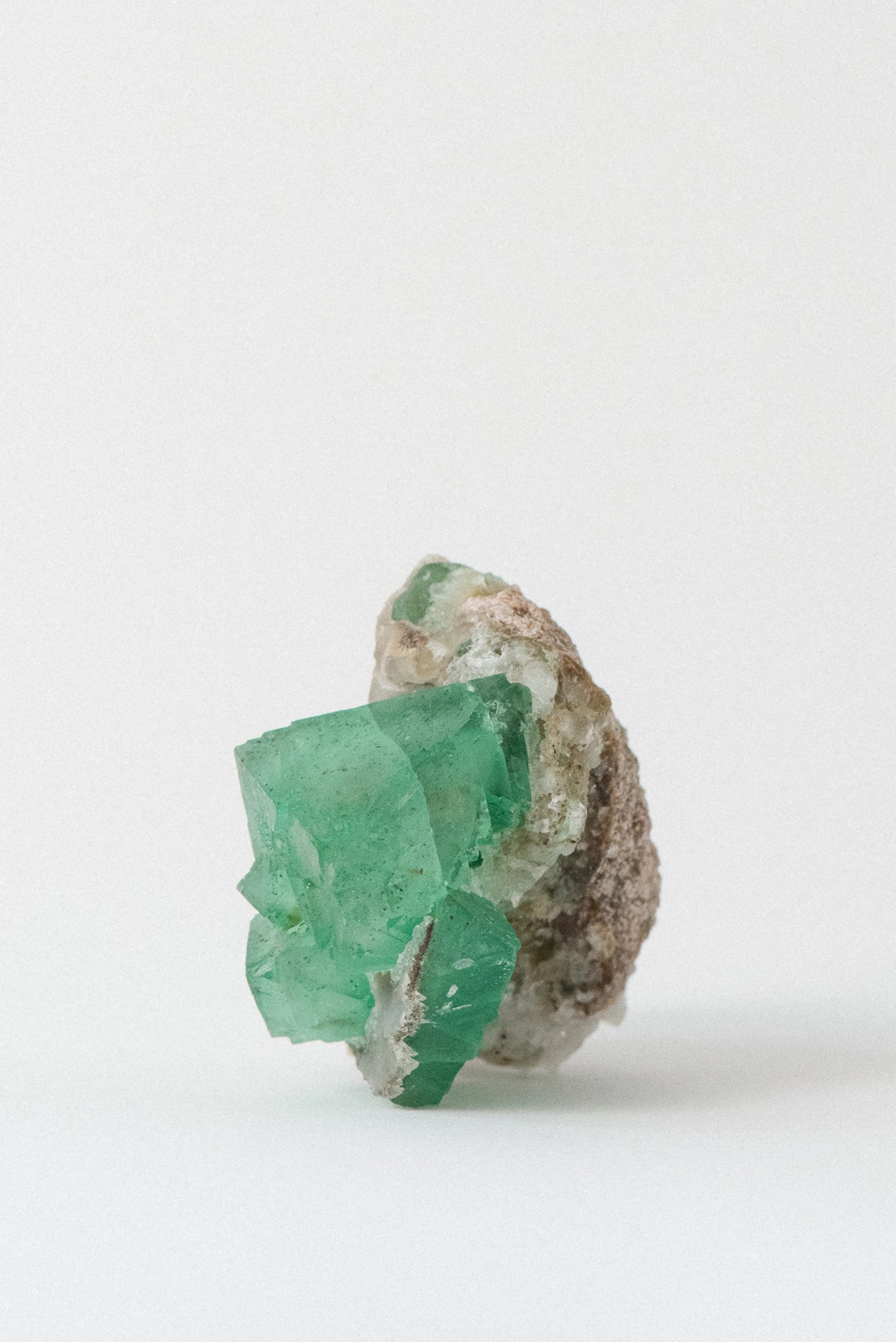 Vibrant gemmy green fluorite crystals on white quartz base, natural mineral