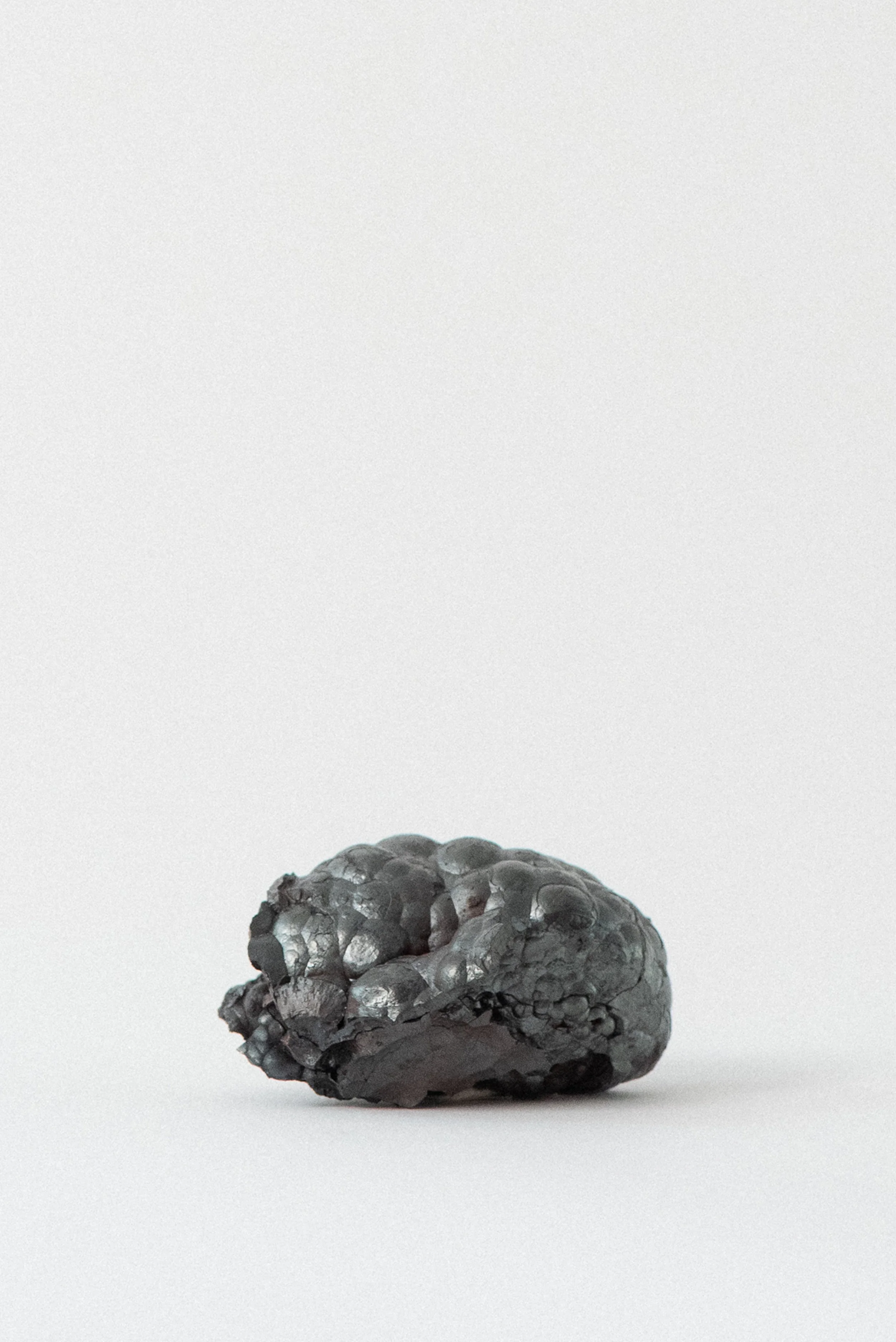 Natural, ethically sourced hematite specimen with bulbous growths and reflective surface from New Mexico.