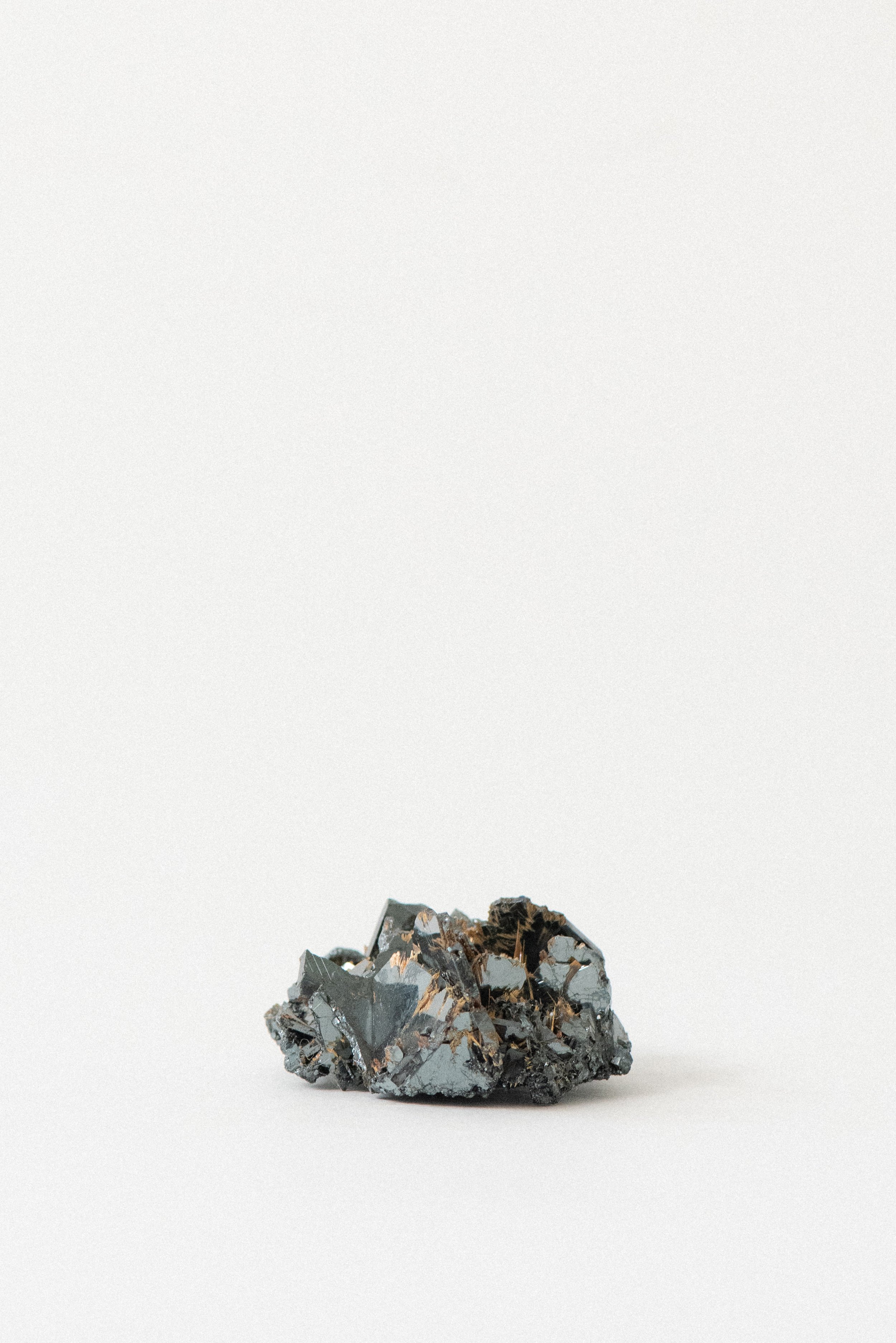 Textured surface of hematite rose with reflective metallic luster and rutile highlights