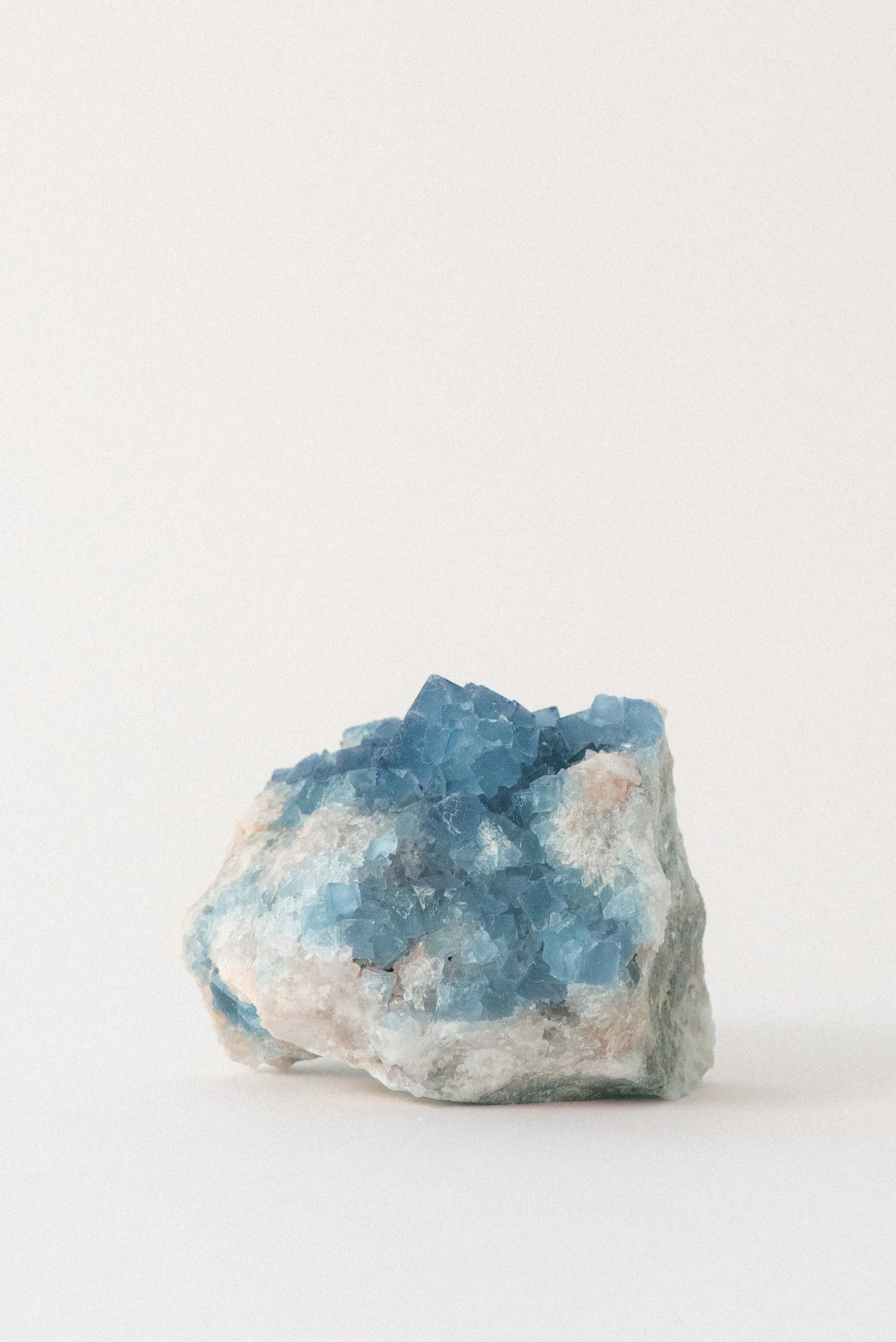 Side view of blue and purple fluorite cluster from Blanchard Mine, Hansonburg District, New Mexico. Vivid cubic formation on white and tan matrix. Crystal Voyager specimen.