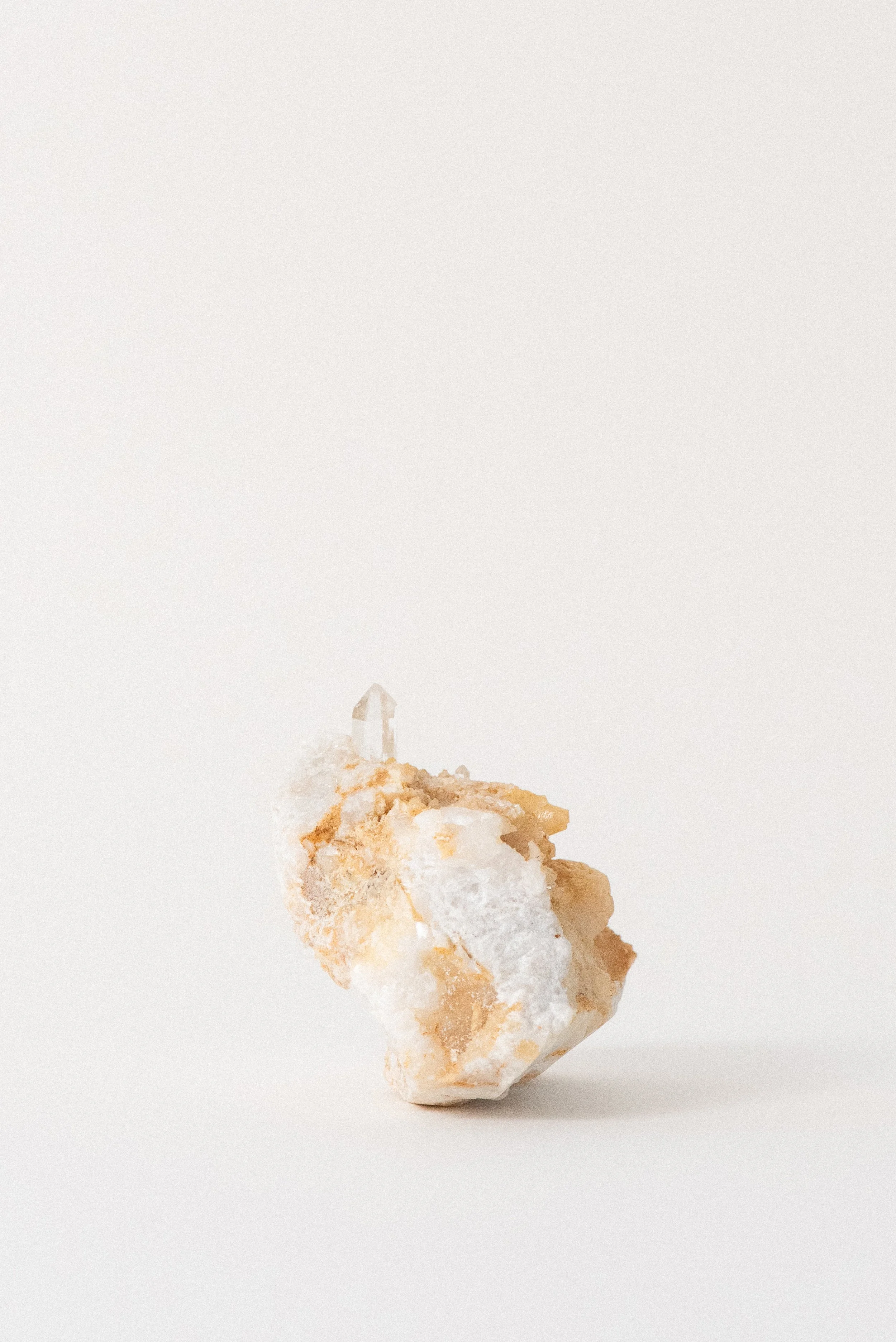 Side view of quartz crystal on Carrara marble from La Facciata Quarry in Italy, showing natural clarity and mineral texture, photographed for Crystal Voyager.