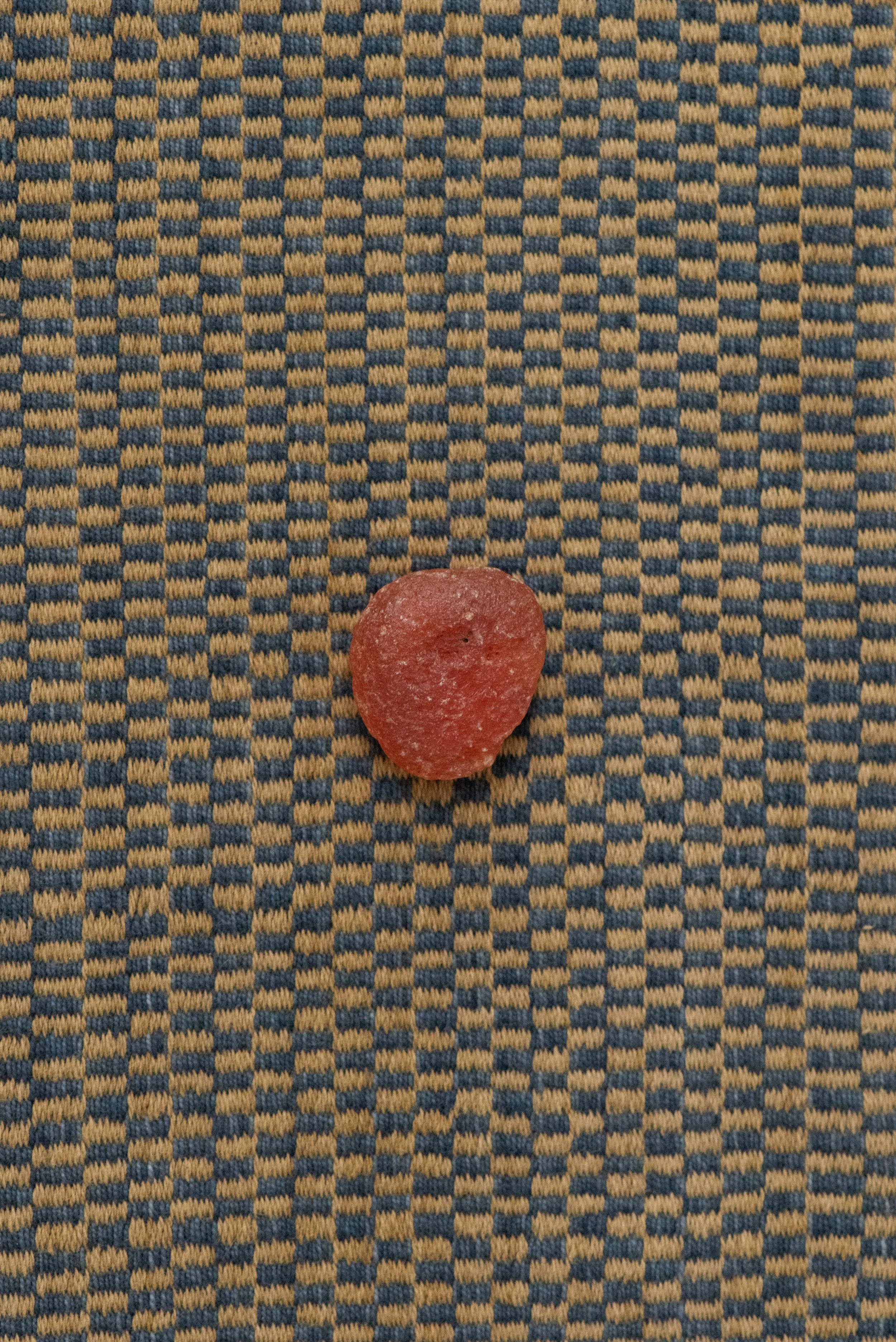 Vintage raw Carnelian crystal from Africa on patterned textile background