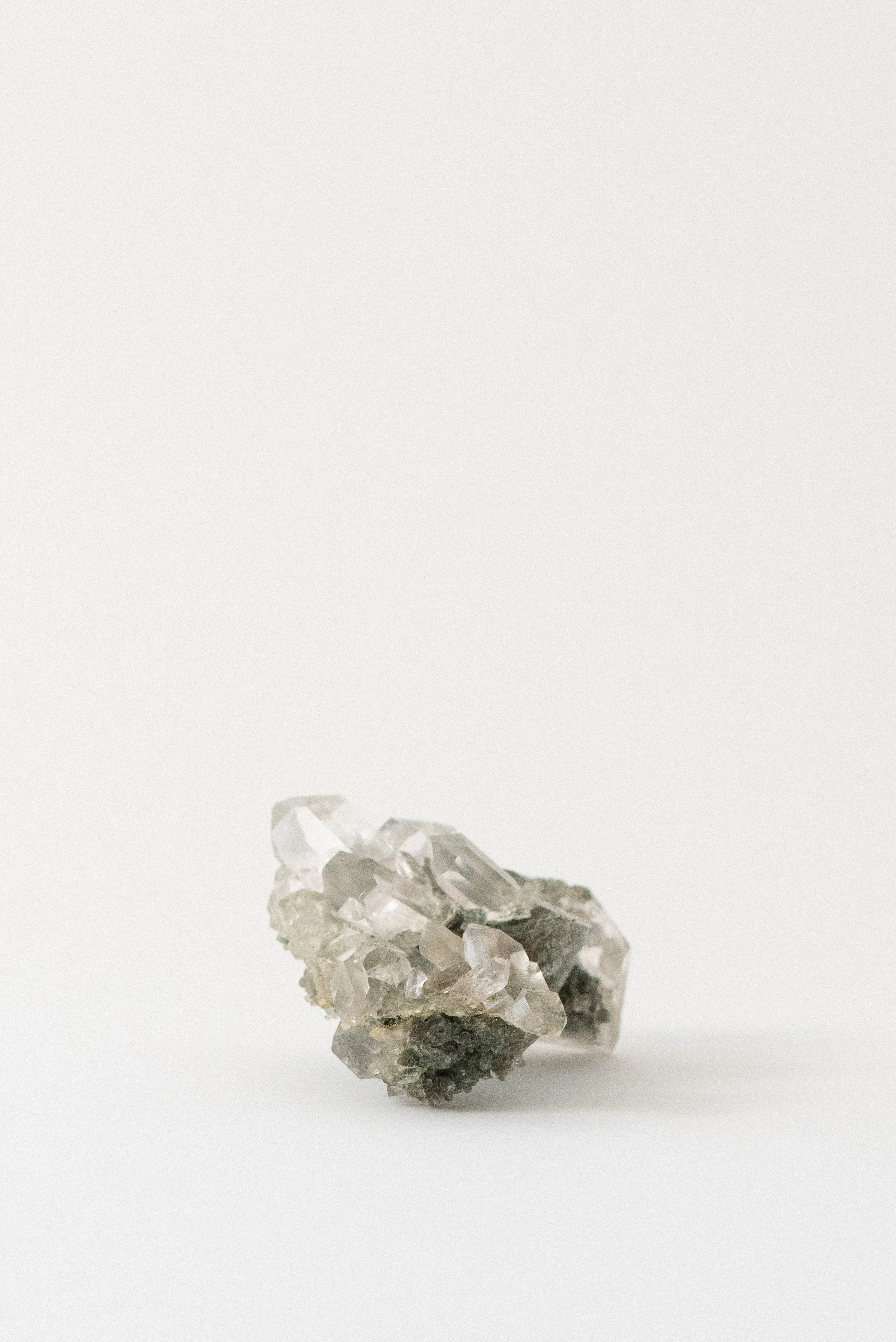 Himalayan quartz crystal cluster with chlorite, golden rutile, and anatase from Manihar, Kullu Valley, Himachal Pradesh, India, photographed on a white background.