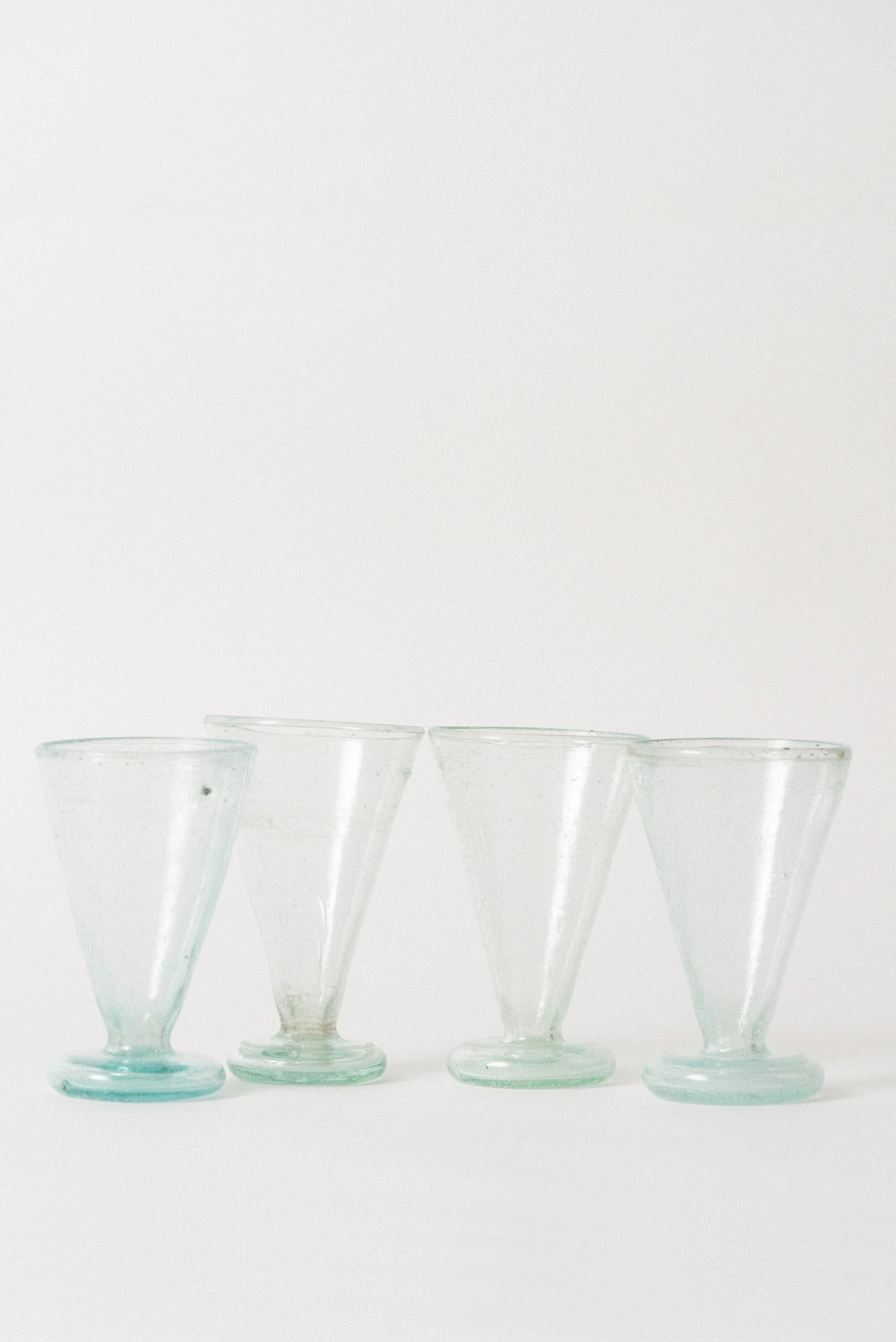 Set of four handblown Egyptian tea glasses made from clear seed glass with natural bubbles and rounded bases.
