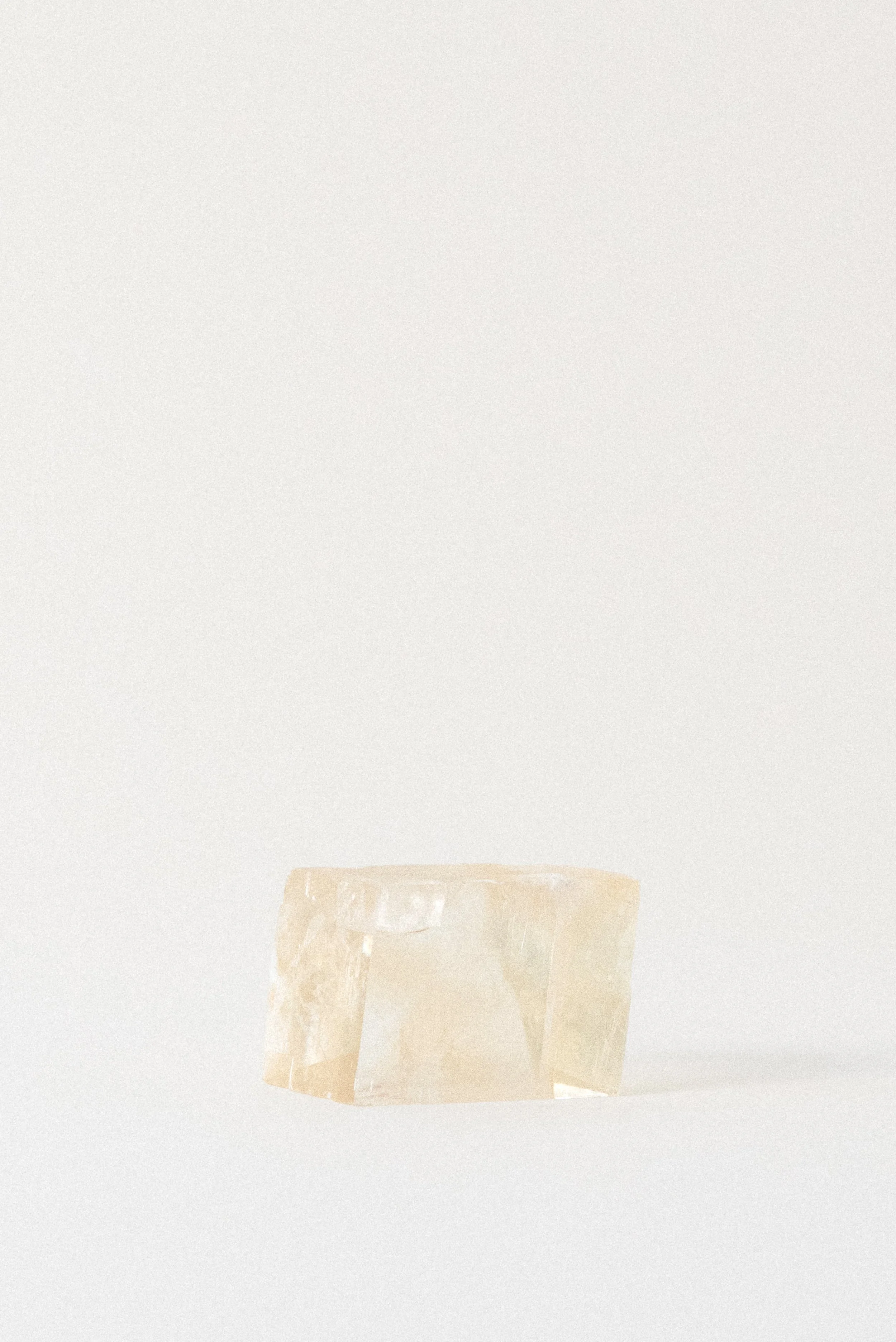 Yellow calcite rhomboid crystal from Aurangabad, India, photographed in soft neutral lighting against a white background