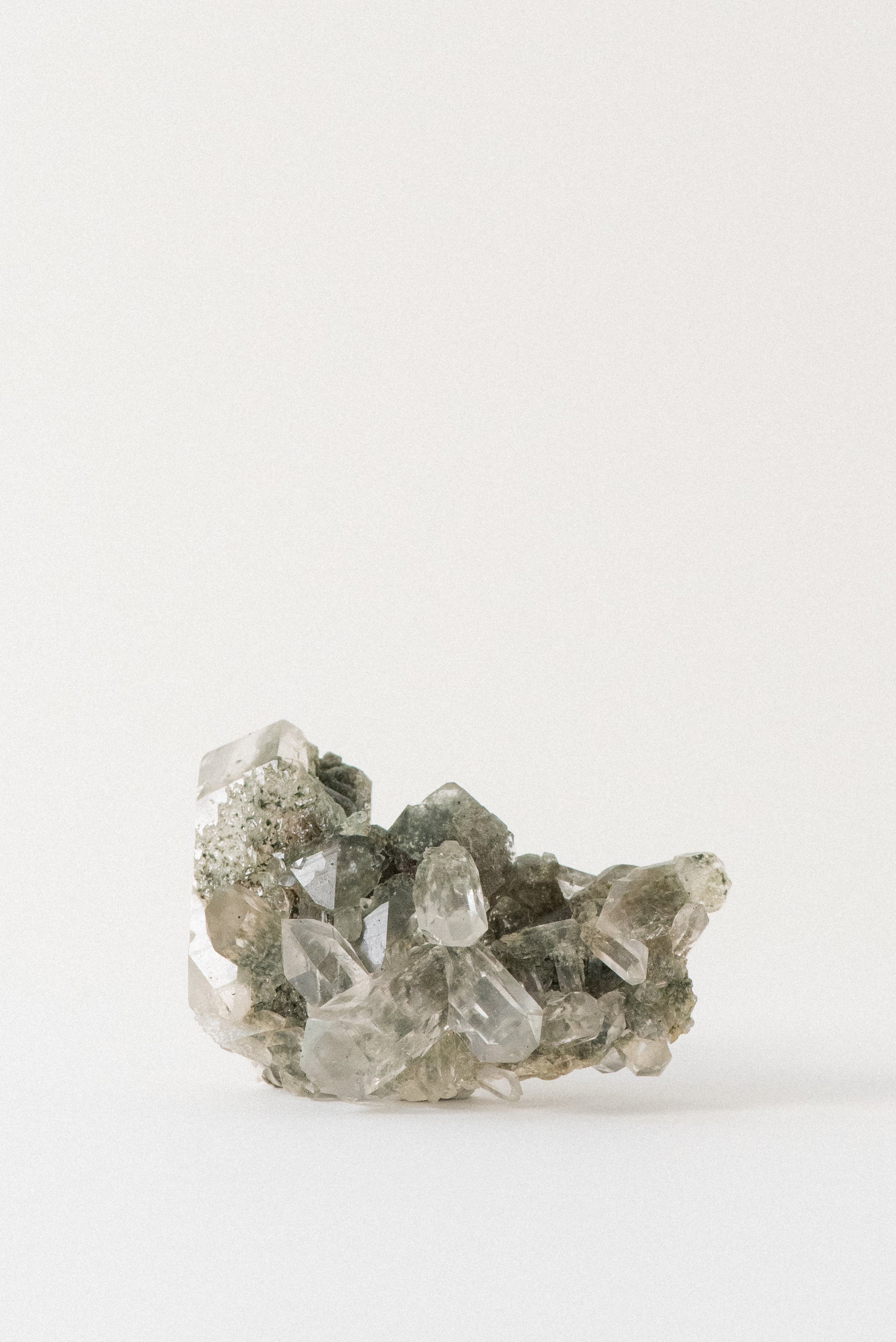 Chlorite quartz cluster from the Himalayas, featuring clear crystal points and mossy green mineral inclusions, photographed on a white background. Origin: Manihar, Kullu, Himachal Pradesh, India.