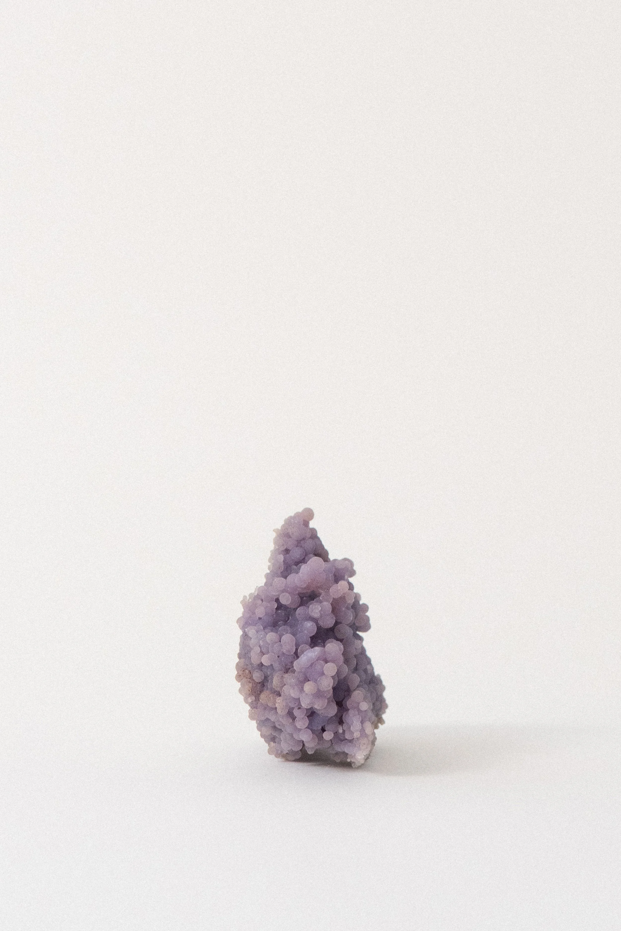 Standing formation of purple grape agate from Sulawesi, Indonesia, featuring botryoidal clusters and a rich violet-lavender gradient.