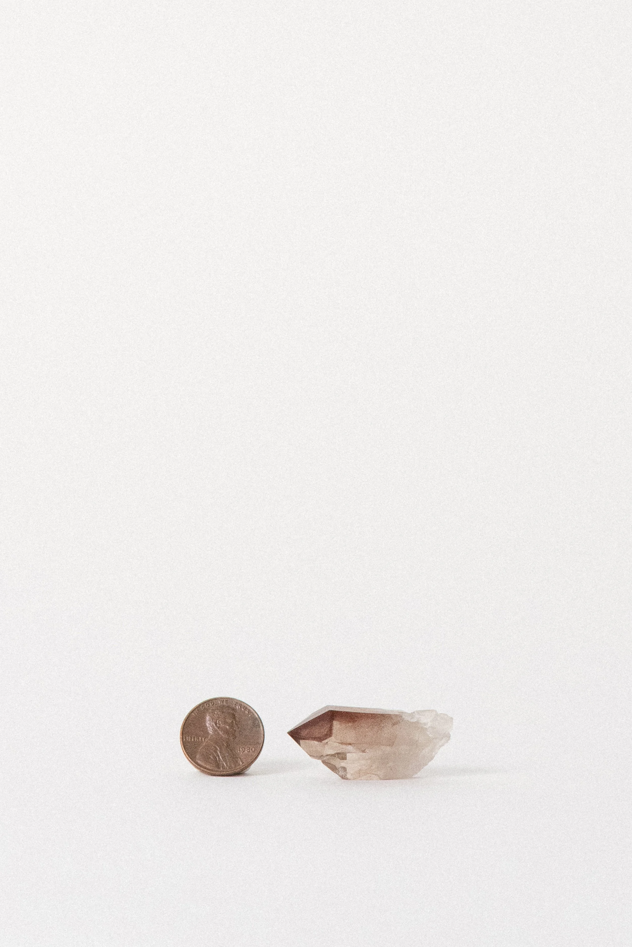 Red Quartz specimen next to penny for scale, Orange River origin.