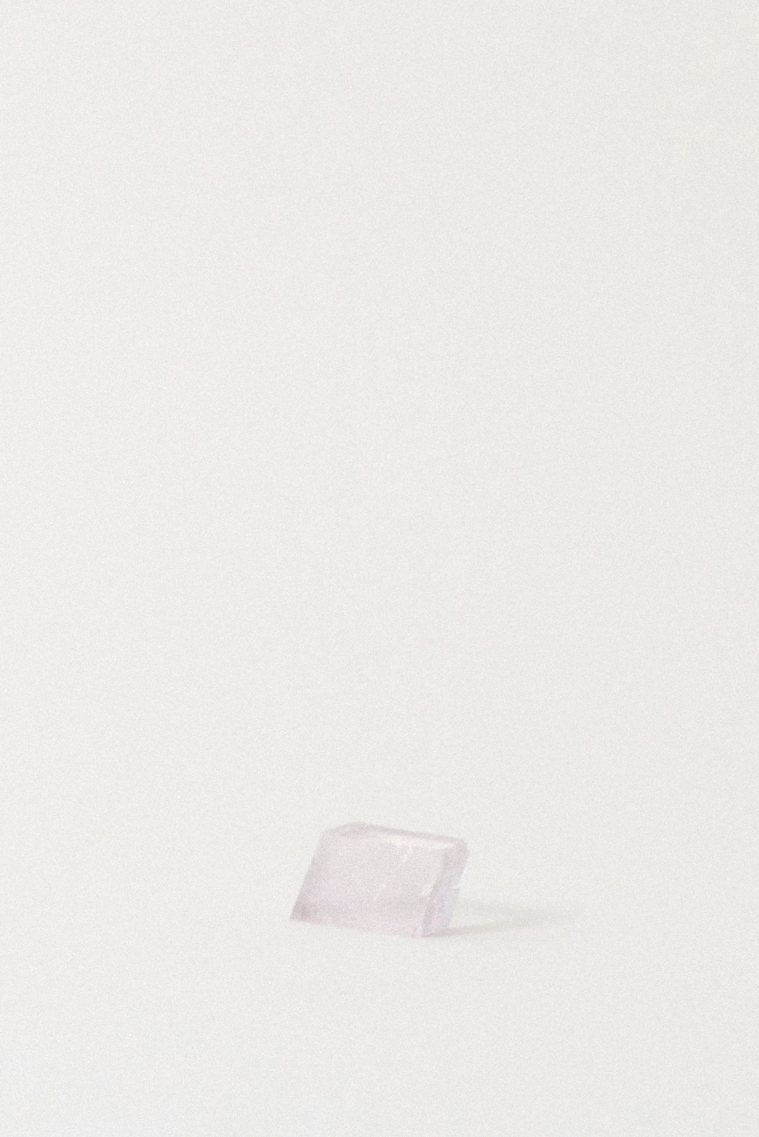 Lavender Balmat Calcite crystal from Balmat, New York, photographed at a slight angle to show clarity and shape against a minimal white background.