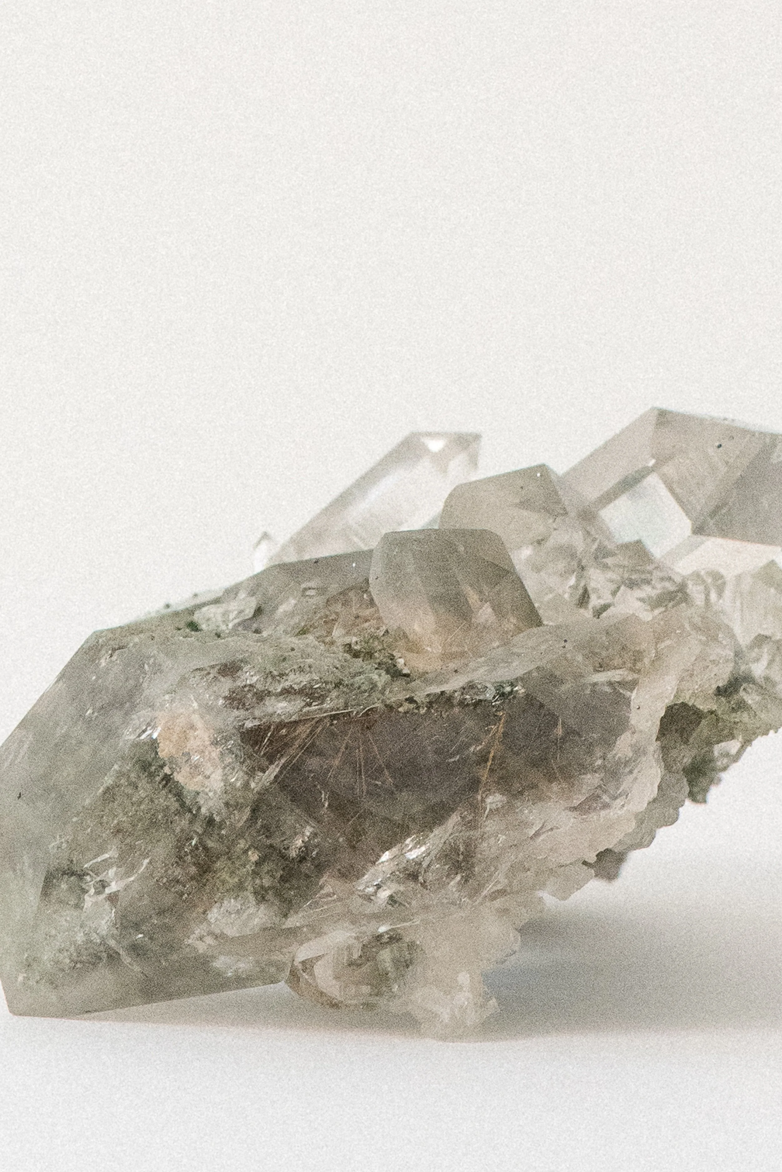 Close-up of Himalayan quartz with visible chlorite and golden rutile inclusions, highlighting fine mineral threads and green matrix. Sourced from Manihar, Kullu, Himachal Pradesh, India.