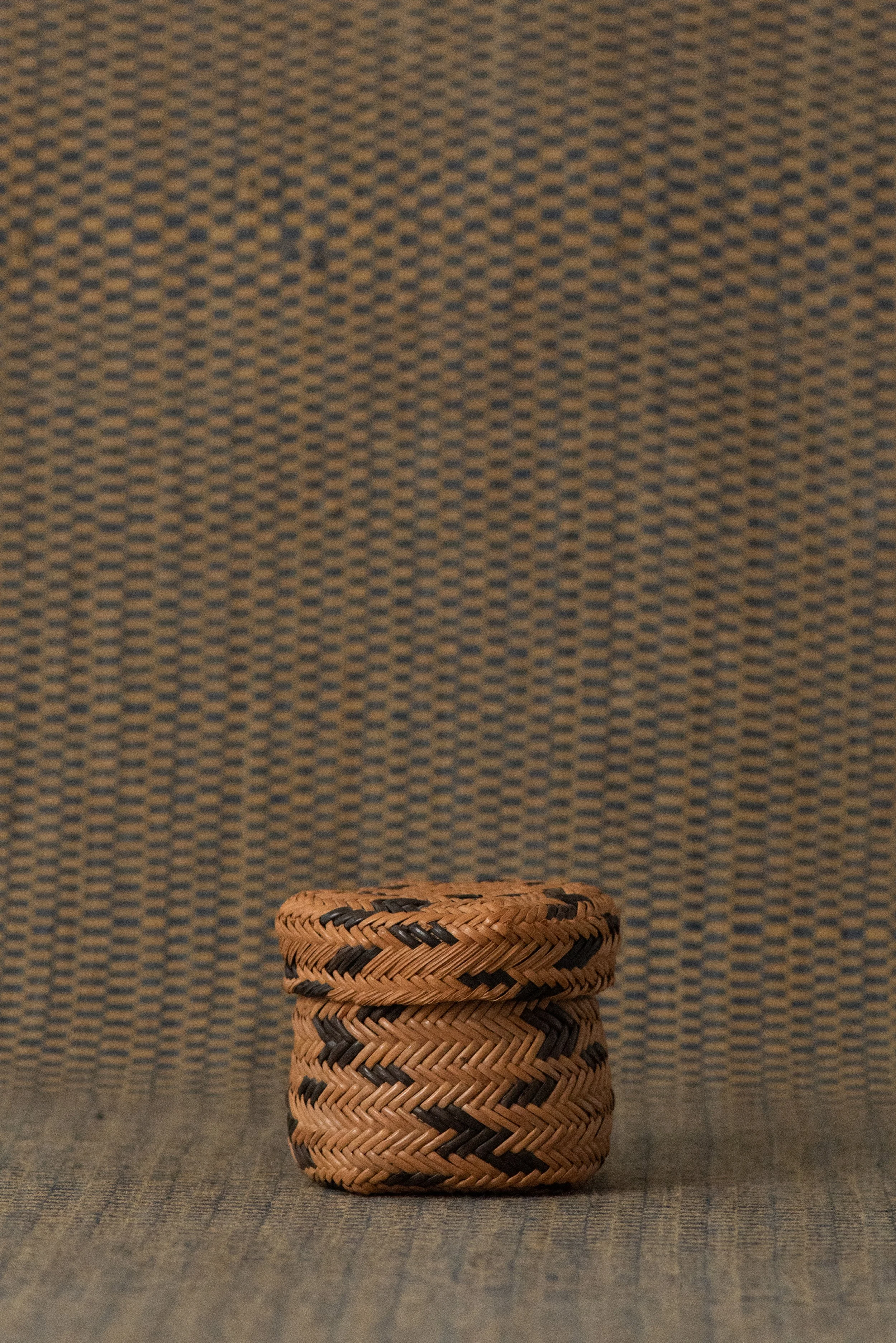 1960s Tarahumara pine needle basket displayed on woven textile, showcasing indigenous Mexican craftsmanship.