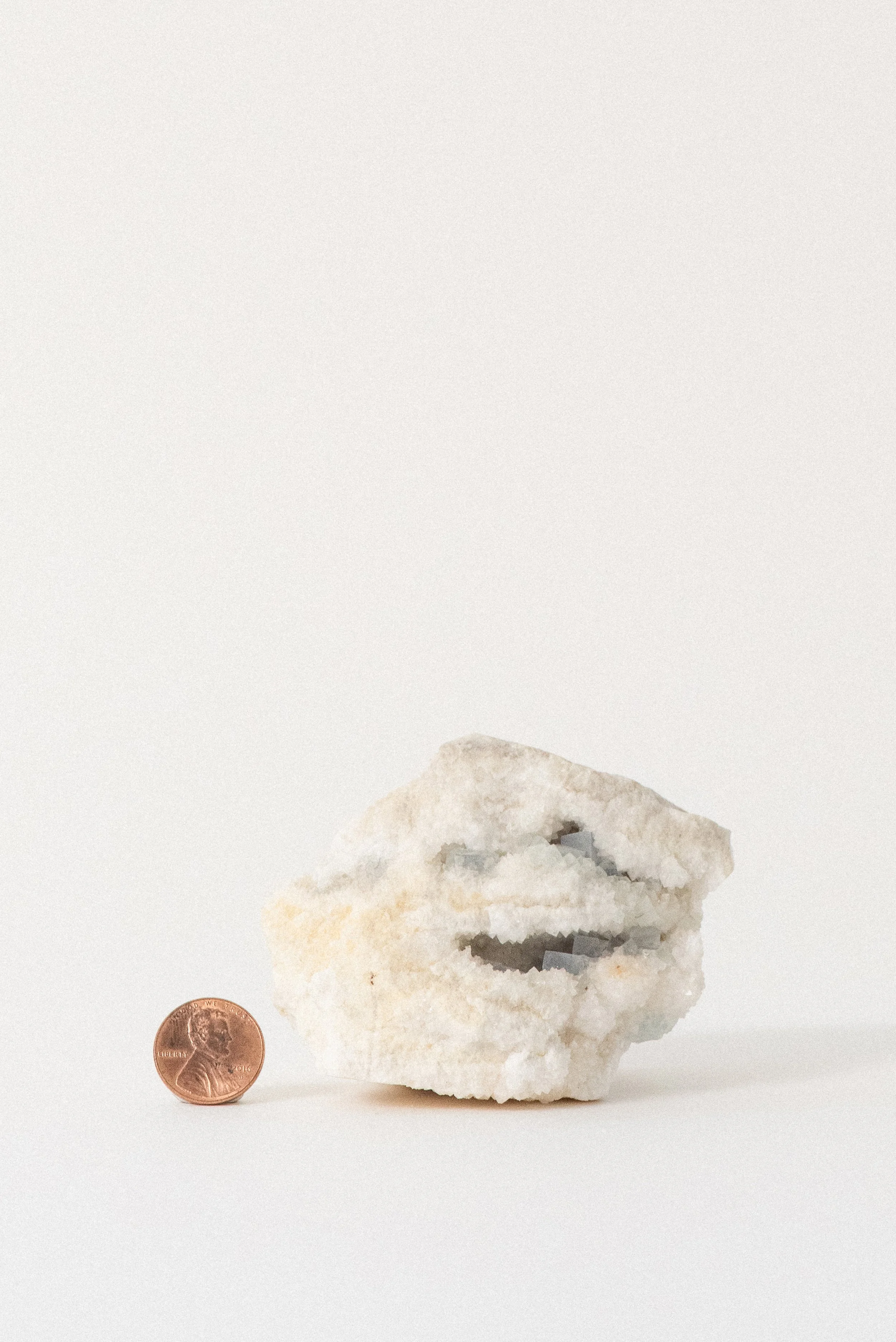 Aqua fluorite crystal specimen on white matrix from Hansonburg Mining District, New Mexico, shown next to a penny for size reference