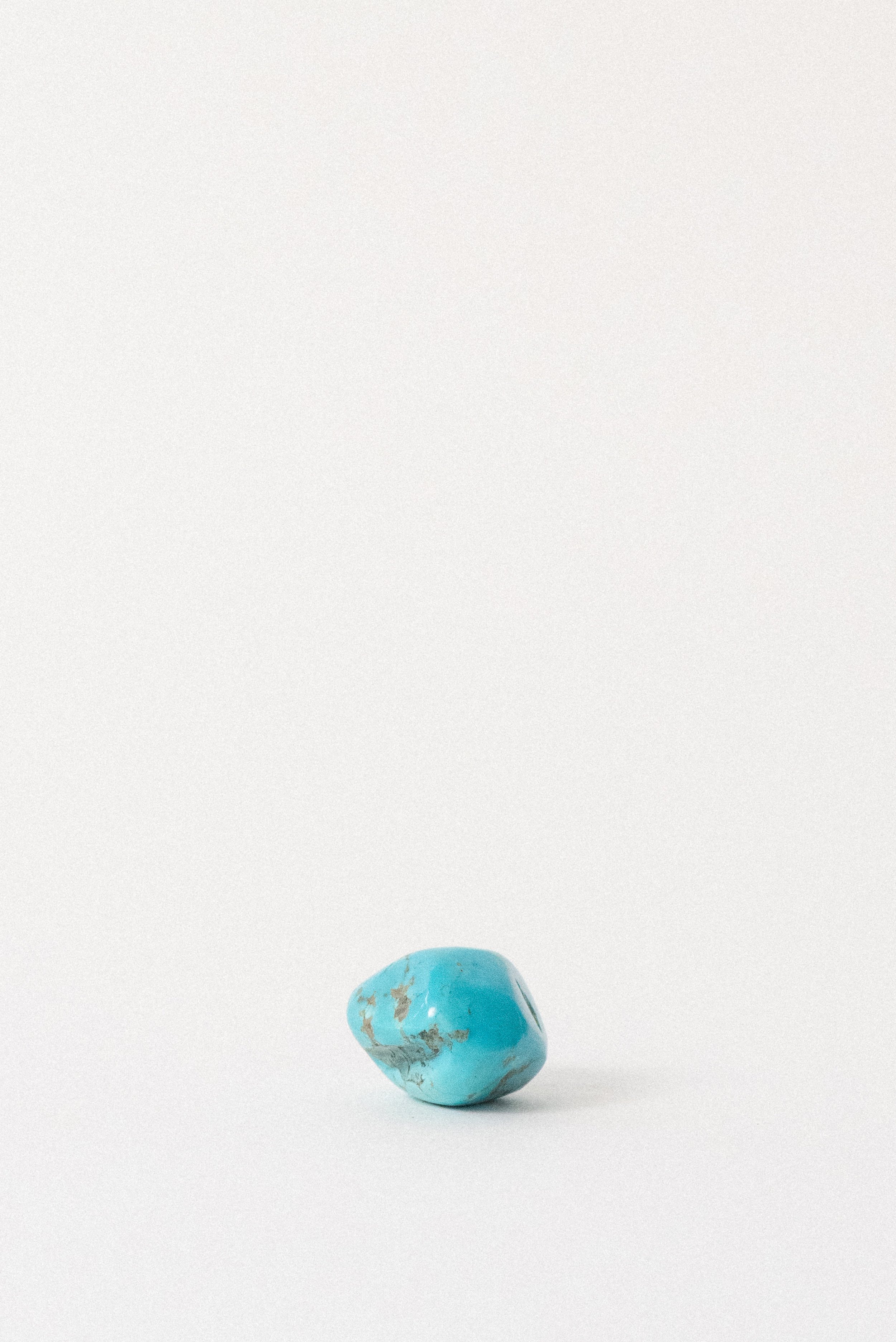 Egyptian turquoise gemstone with smooth bright blue surface and inclusions