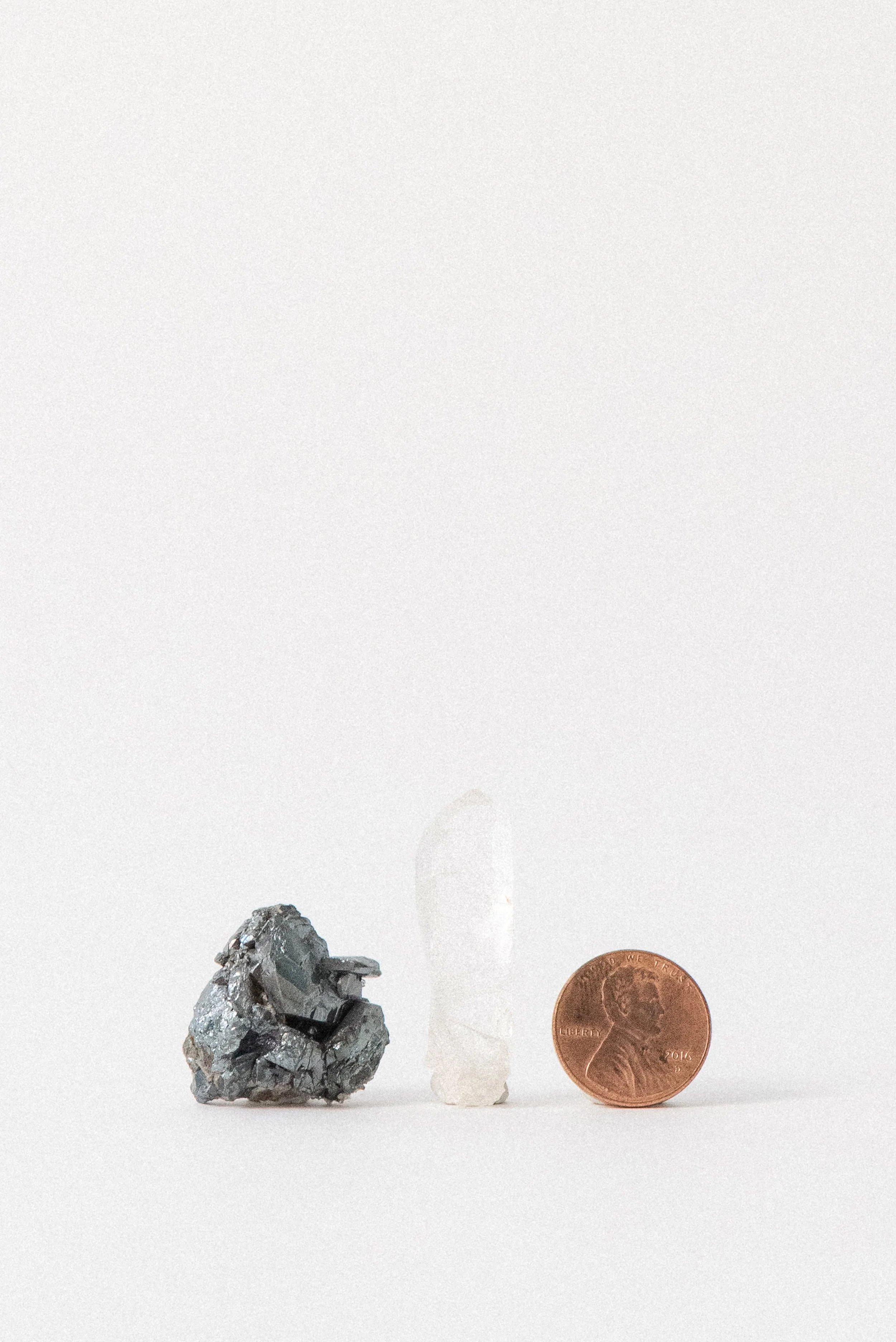 Hematite and clear quartz set shown next to a penny for size reference.