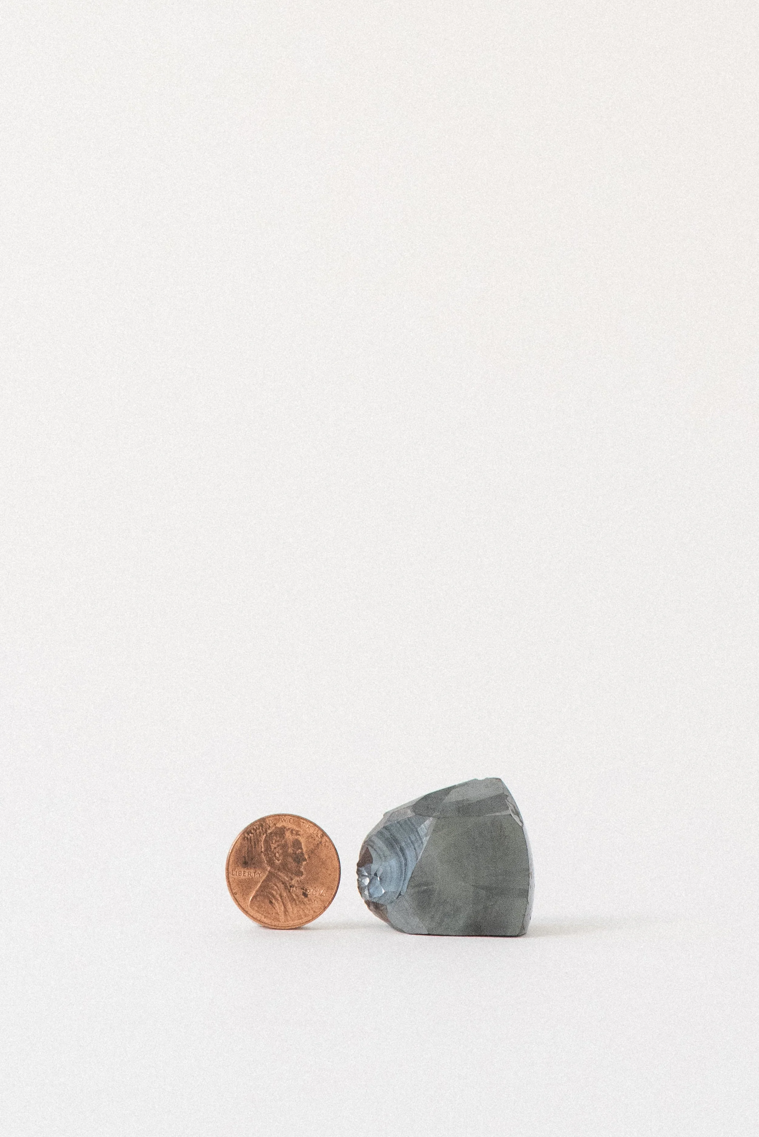 hematite crystal displayed with a penny for size reference