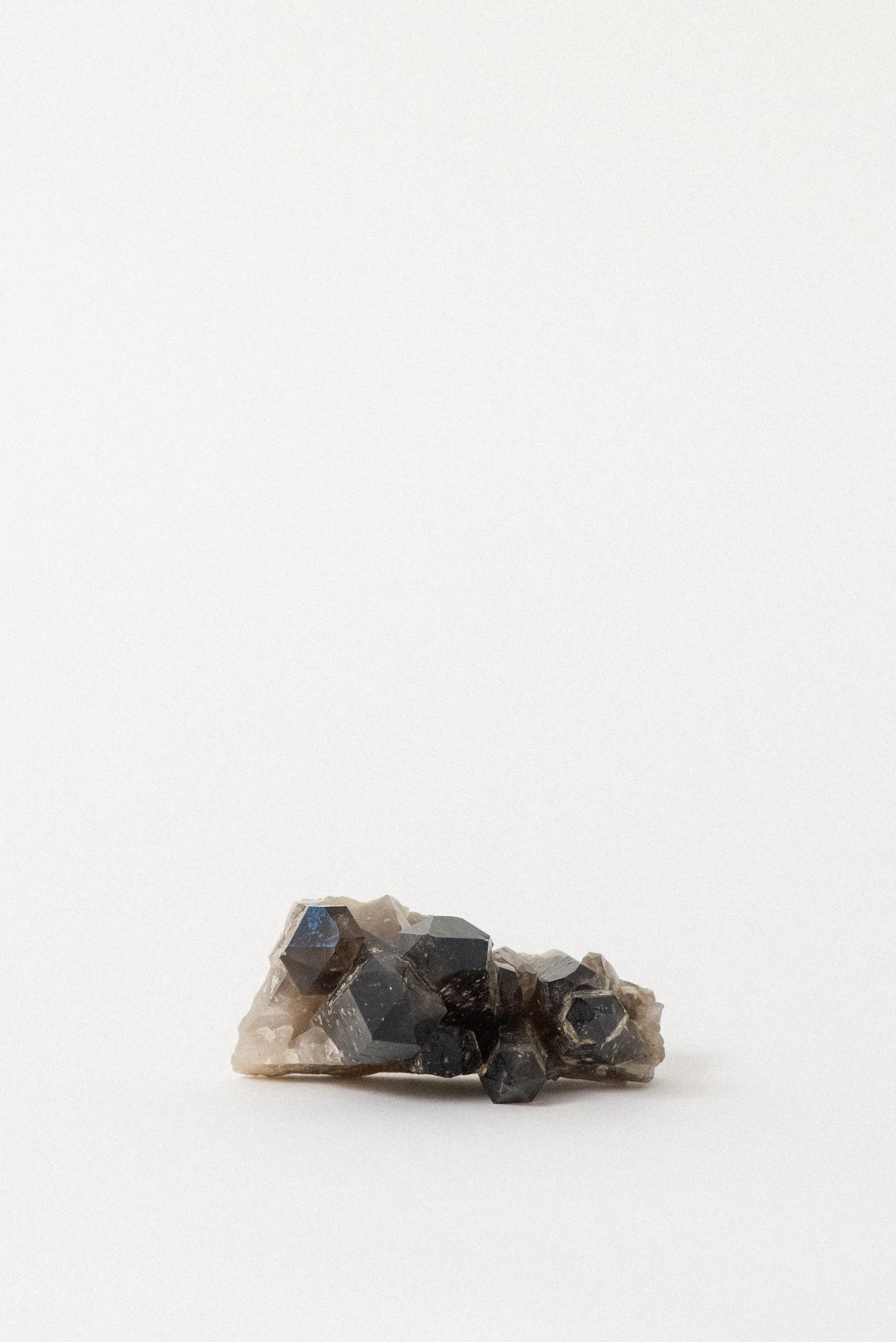 Underside of smoky quartz cluster from Hallelujah Junction, featuring natural matrix and mineral texture.