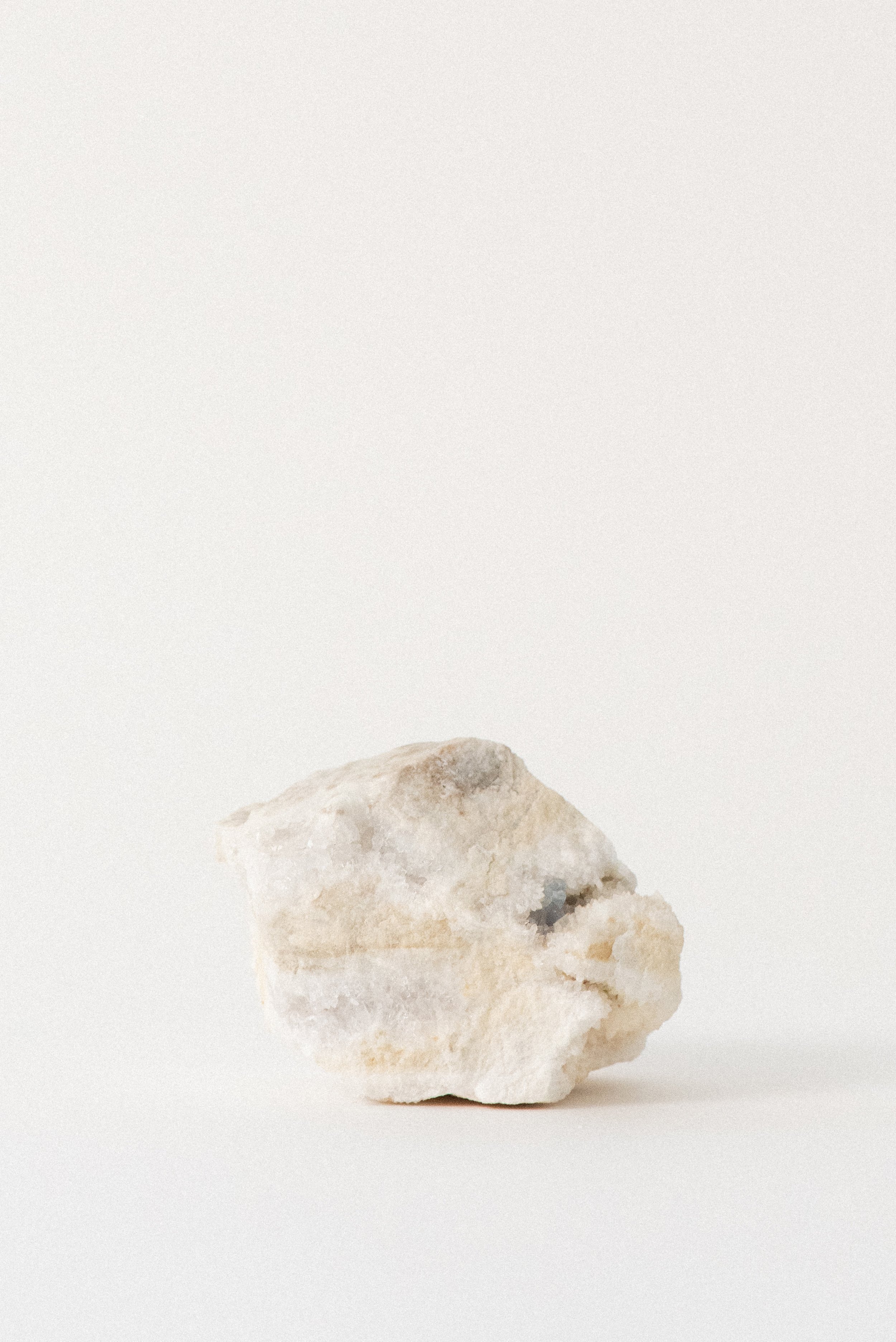 Subtle aqua fluorite embedded in pale white and tan matrix from Hansonburg Mining District, New Mexico, shown on white background