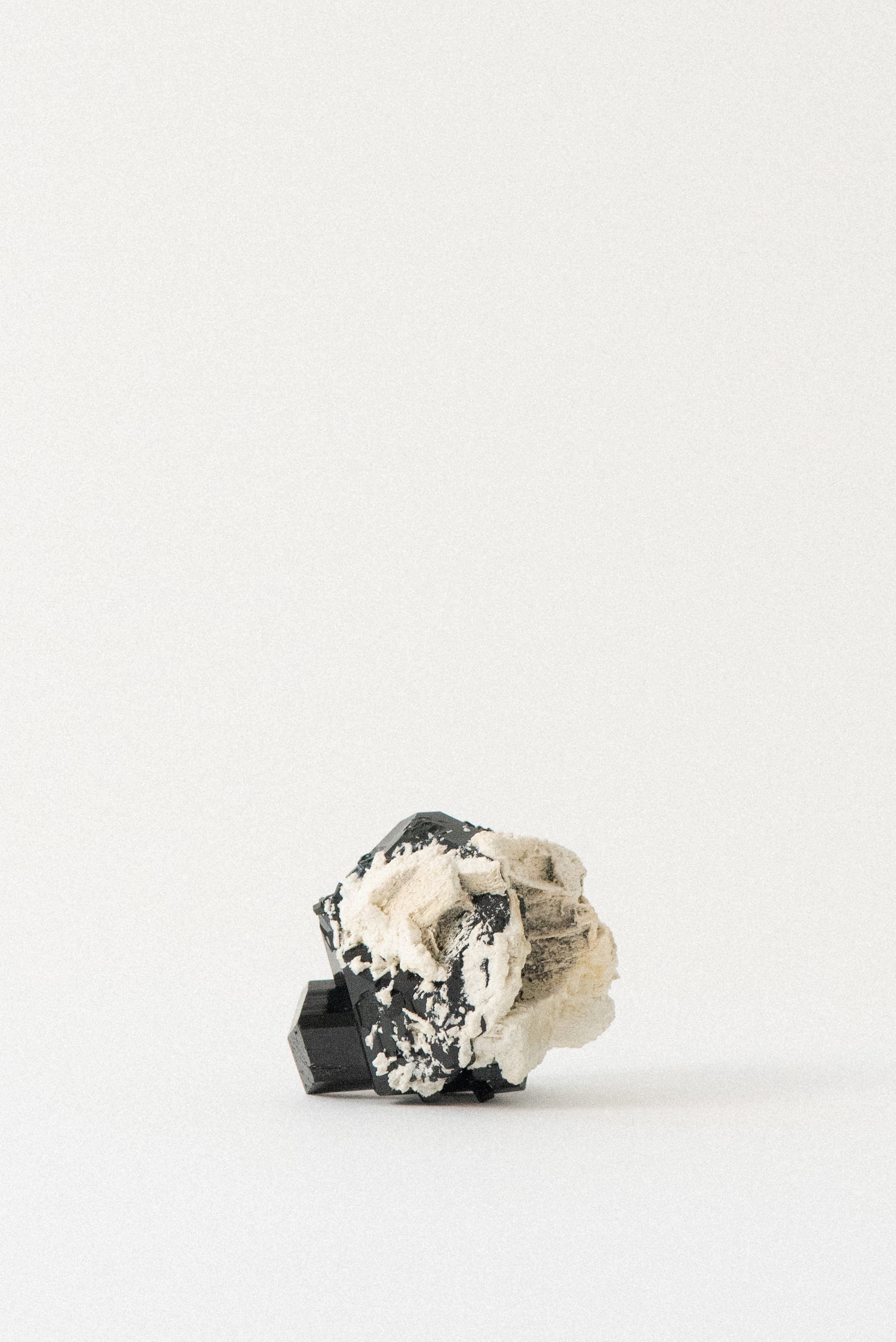 Black tourmaline crystal with pale tan matrix from Erongo Mountains, Namibia, rear angle emphasizing raw mineral texture and angular geometry