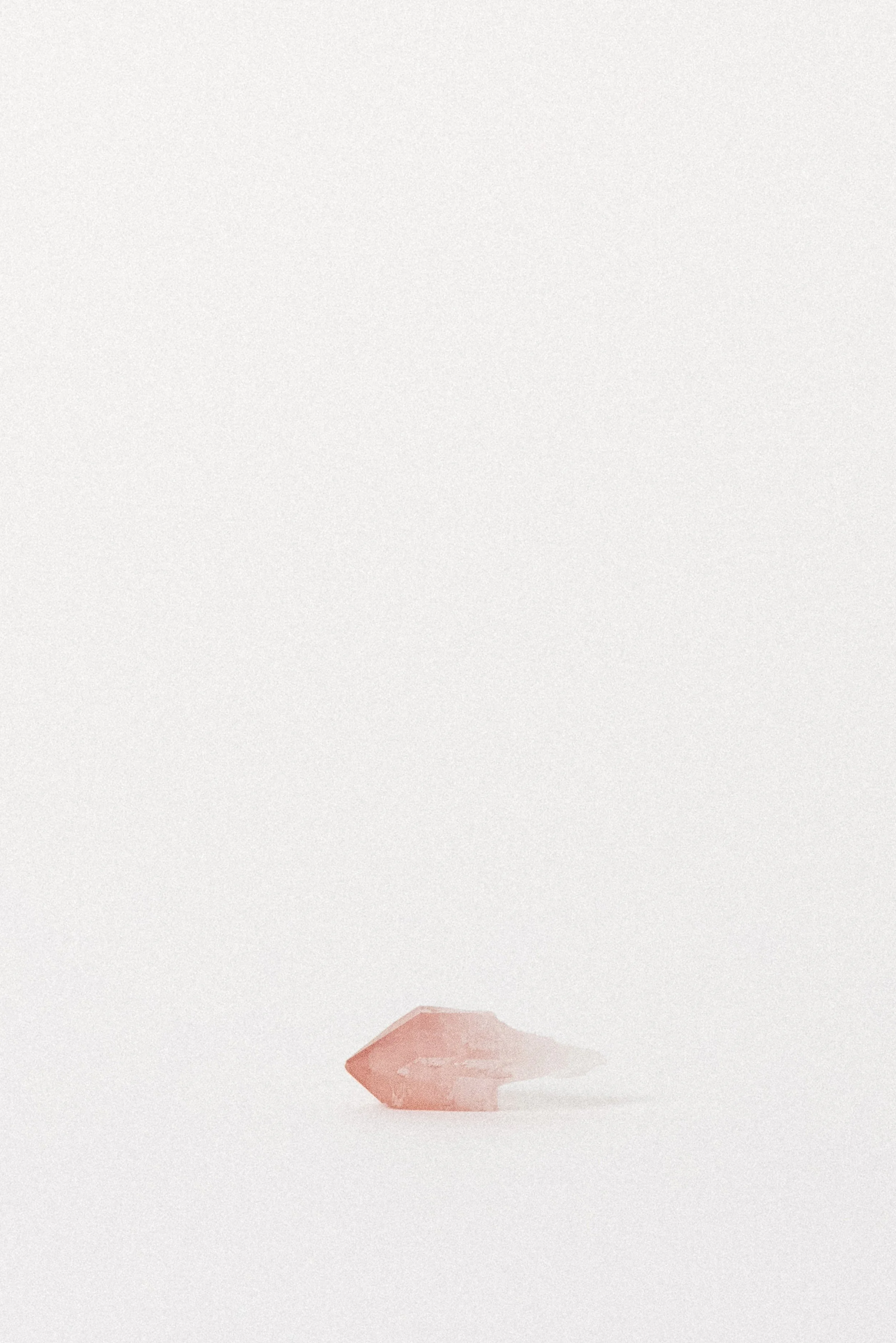 Side view of Pink Quartz point with hematite inclusion and translucent termination.