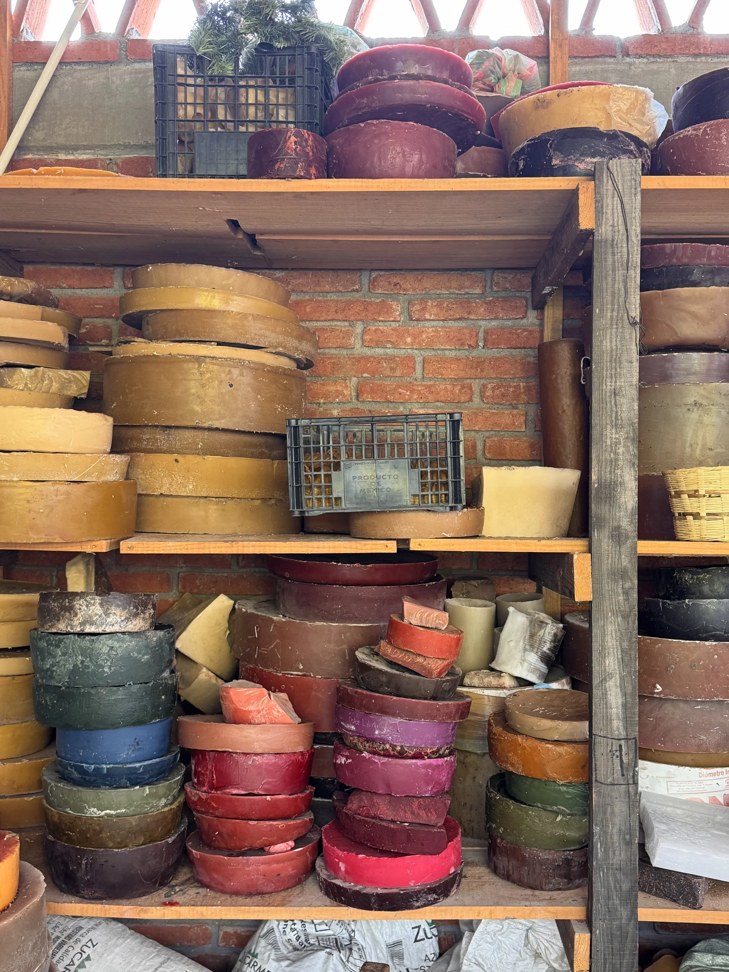 Stacks of colorful beeswax molds in a family workshop in Teotitlán del Valle, Oaxaca, where traditional ceremonial candles are handcrafted