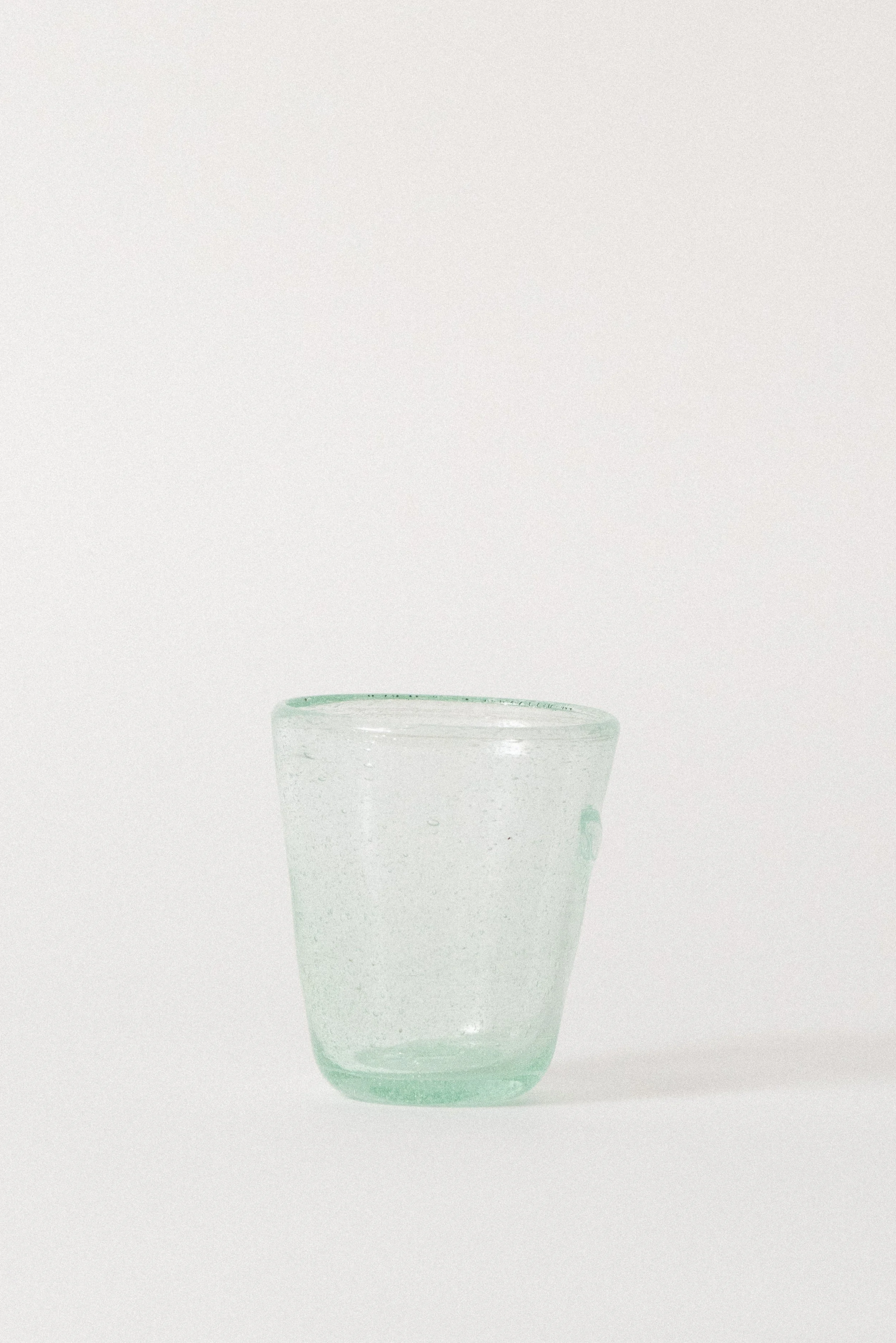 Alternate view of a handblown Egyptian seed glass cup with soft blue-green tint and seed glass texture.