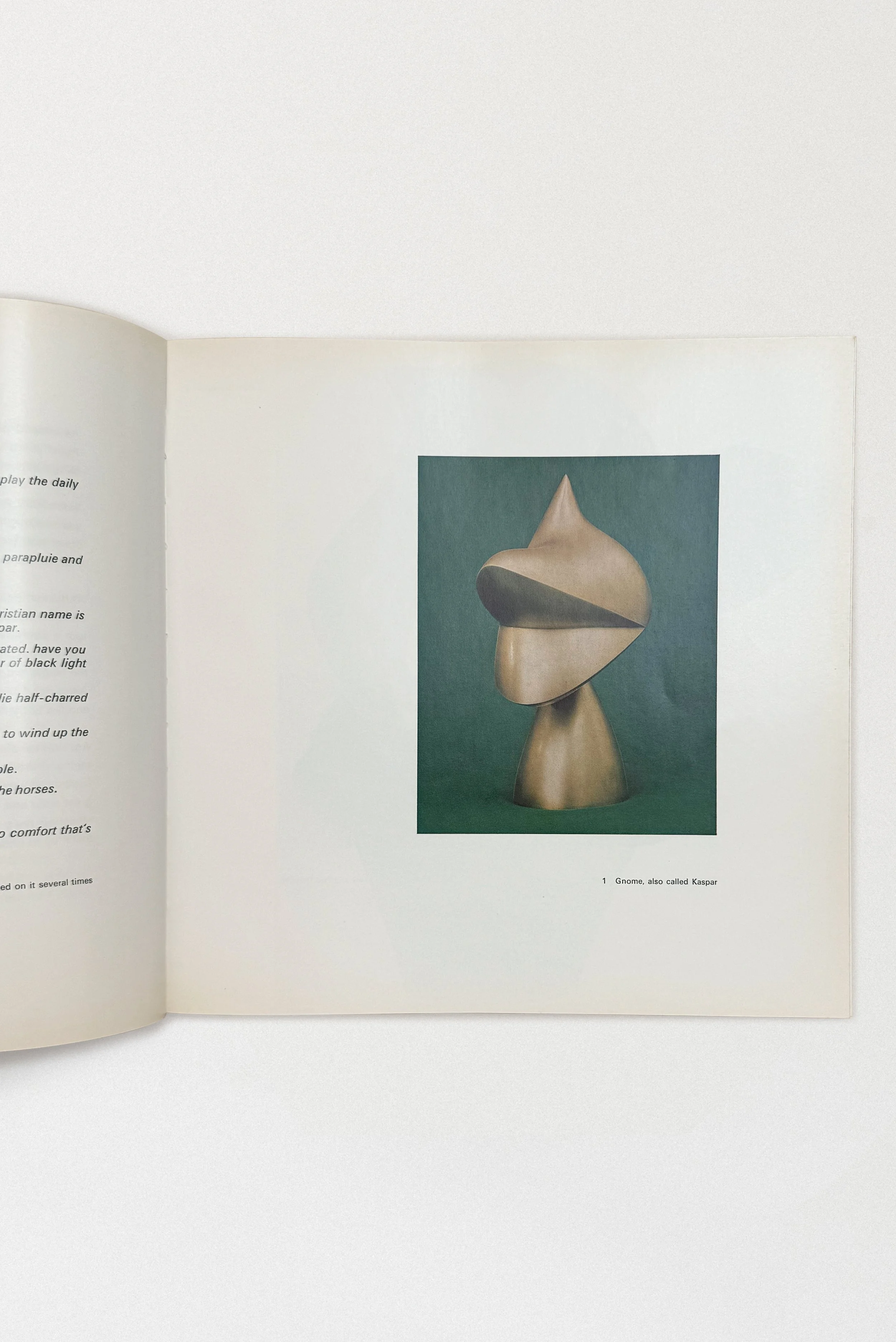 Interior page from Jean Arp: Sculpture, Reliefs, Works on Paper (1975), featuring a color reproduction of Arp’s biomorphic bronze sculpture Gnome, also called Kaspar against a deep green background.