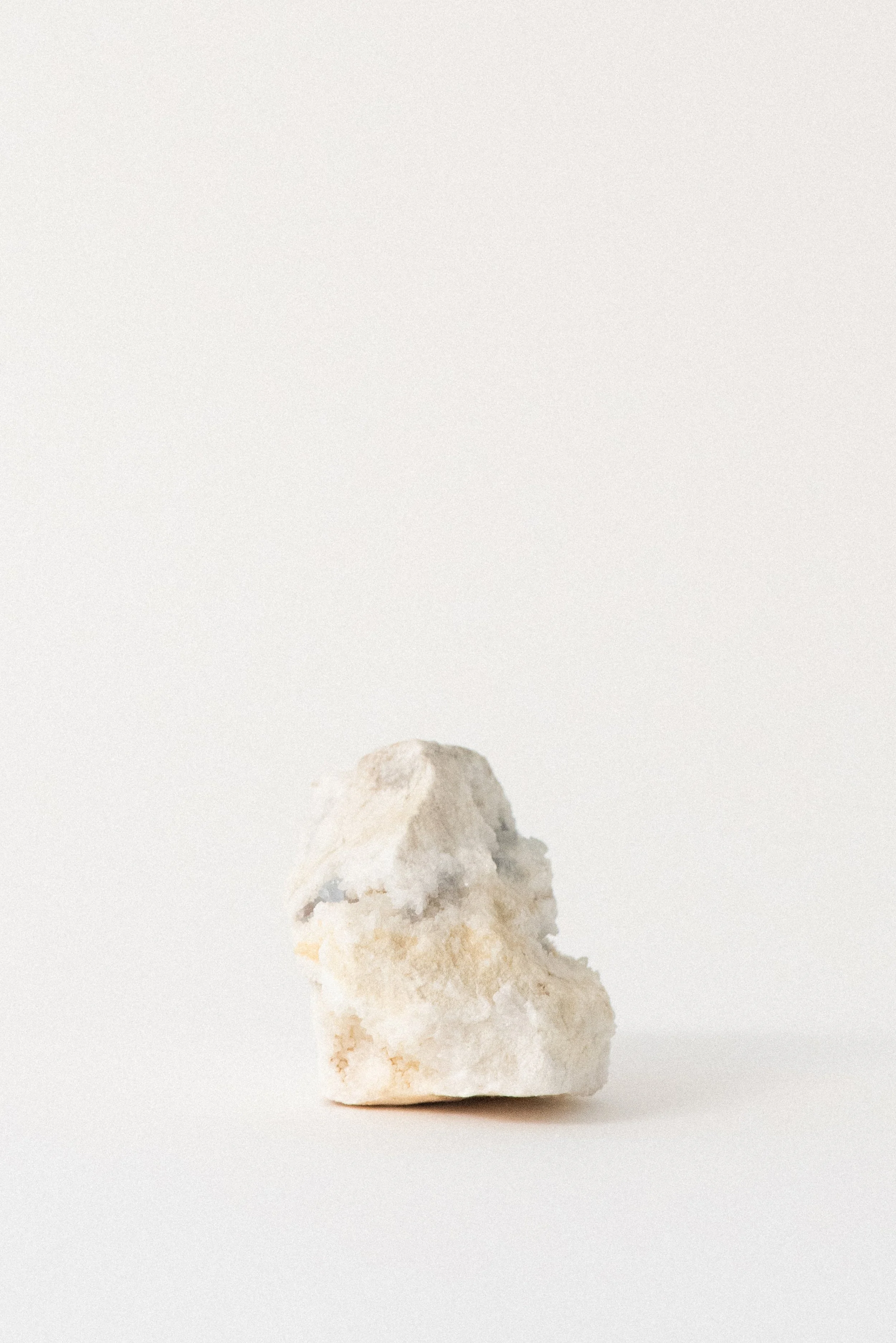Vertical aqua fluorite crystal specimen embedded in pale ochre and white matrix from Hansonburg Mining District, New Mexico, on a white background