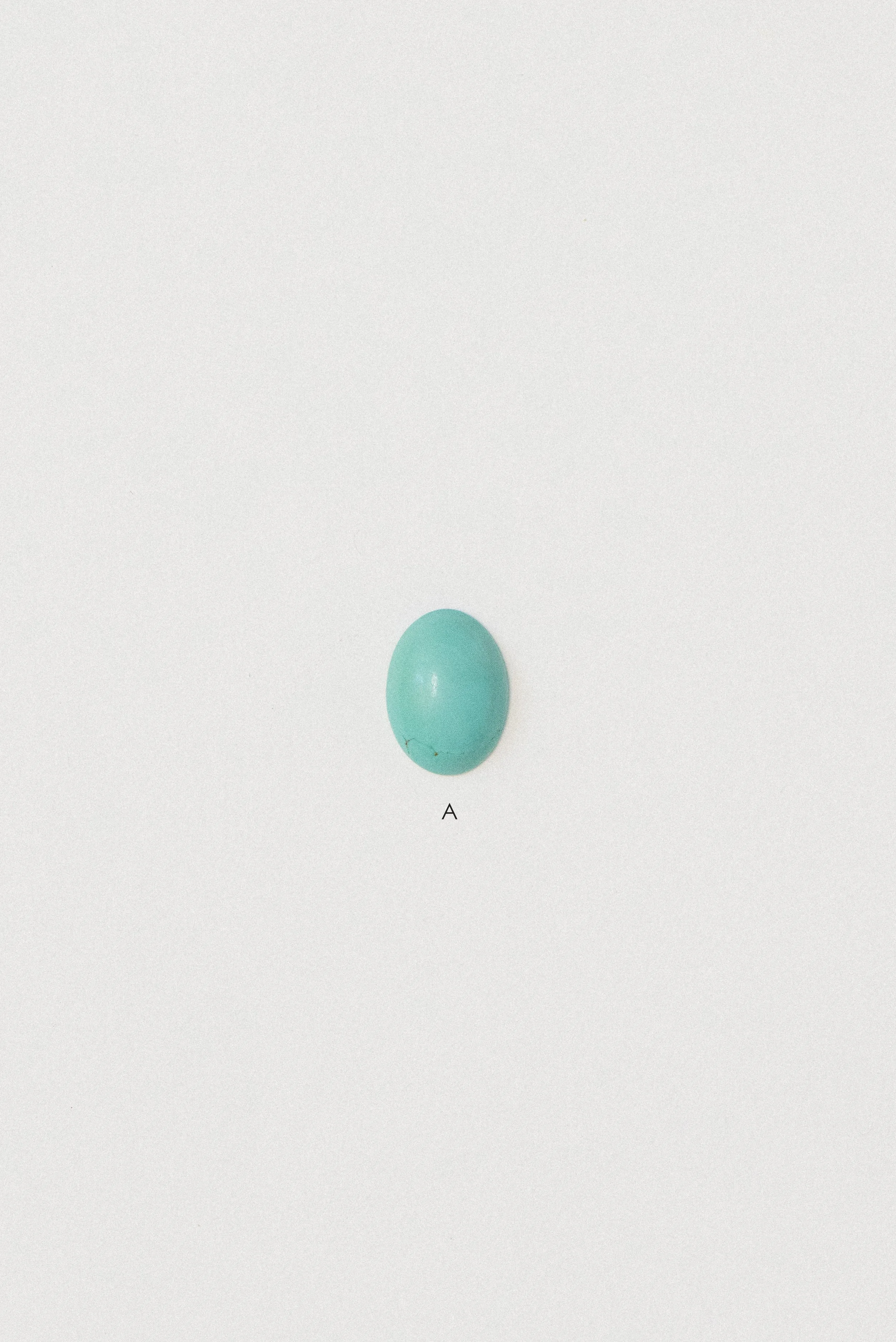 Natural turquoise cabochon from Sinai, Egypt labeled A on a white background.
