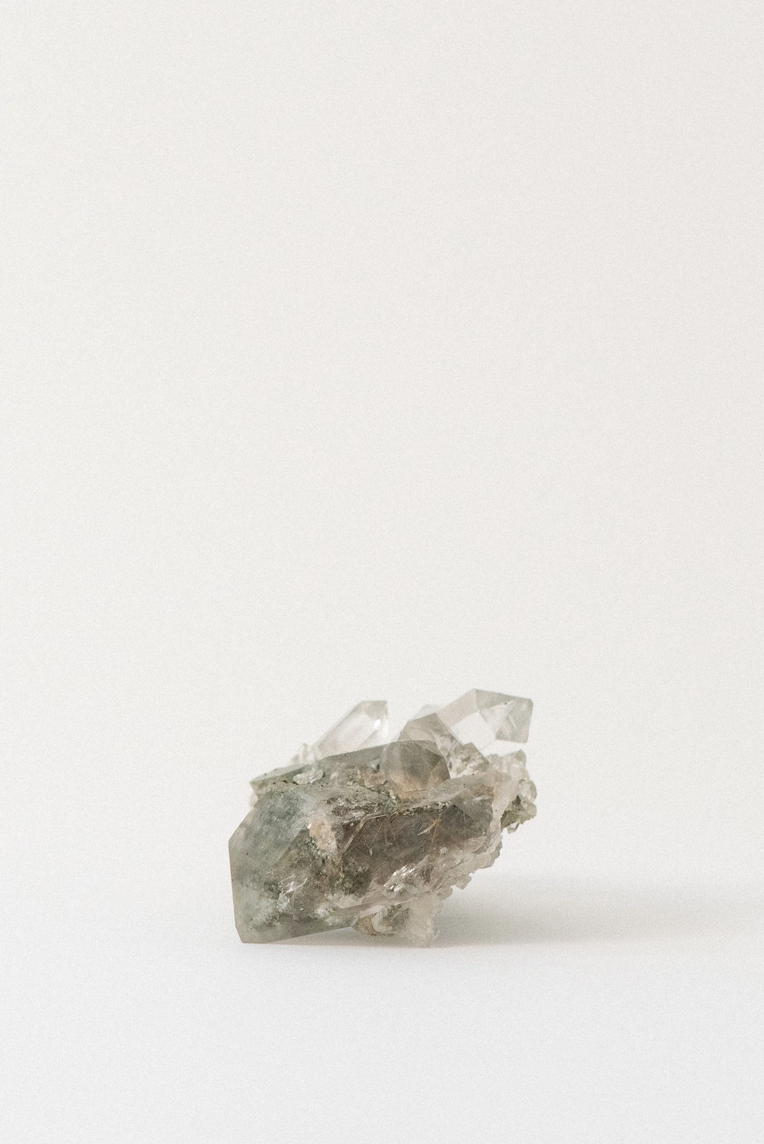 Himalayan quartz specimen with chlorite, golden rutile, and anatase inclusions from Manihar, Kullu, Himachal Pradesh, India, shown on a white background.