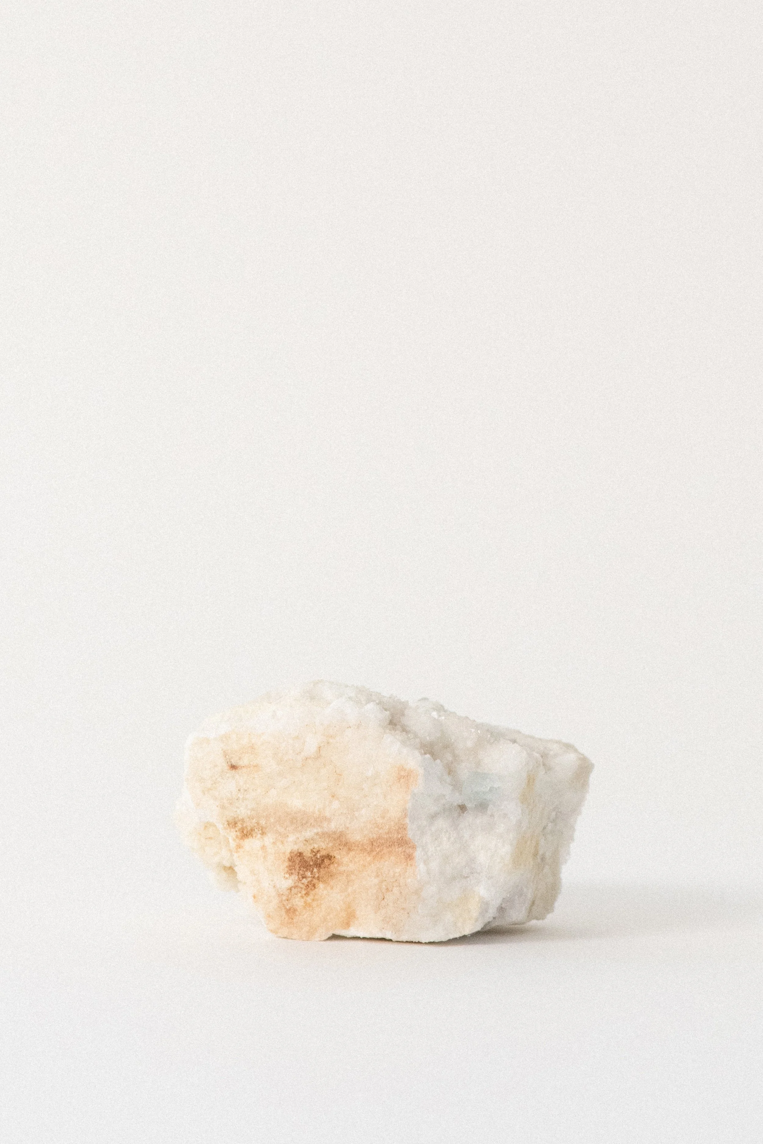 Aqua fluorite crystal specimen partially embedded in white and ochre matrix from Hansonburg Mining District, New Mexico, shown on neutral background