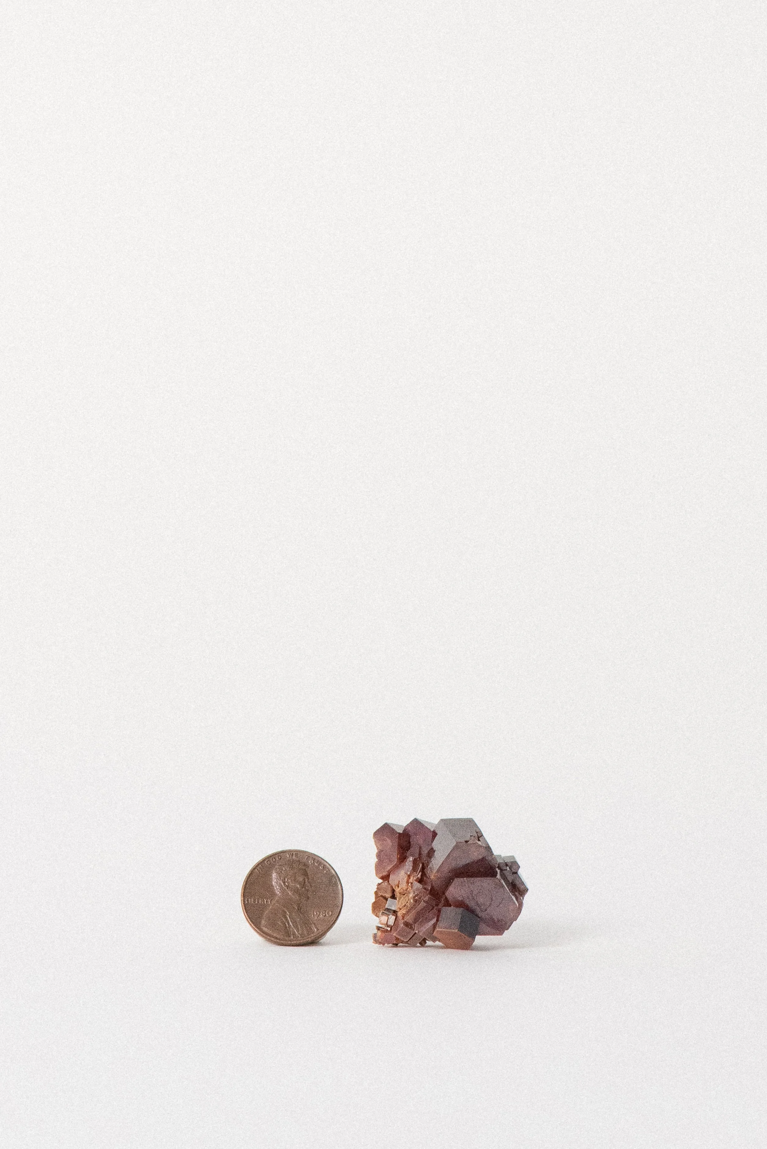 Vanadinite specimen next to penny for scale, Mibladen mining district.