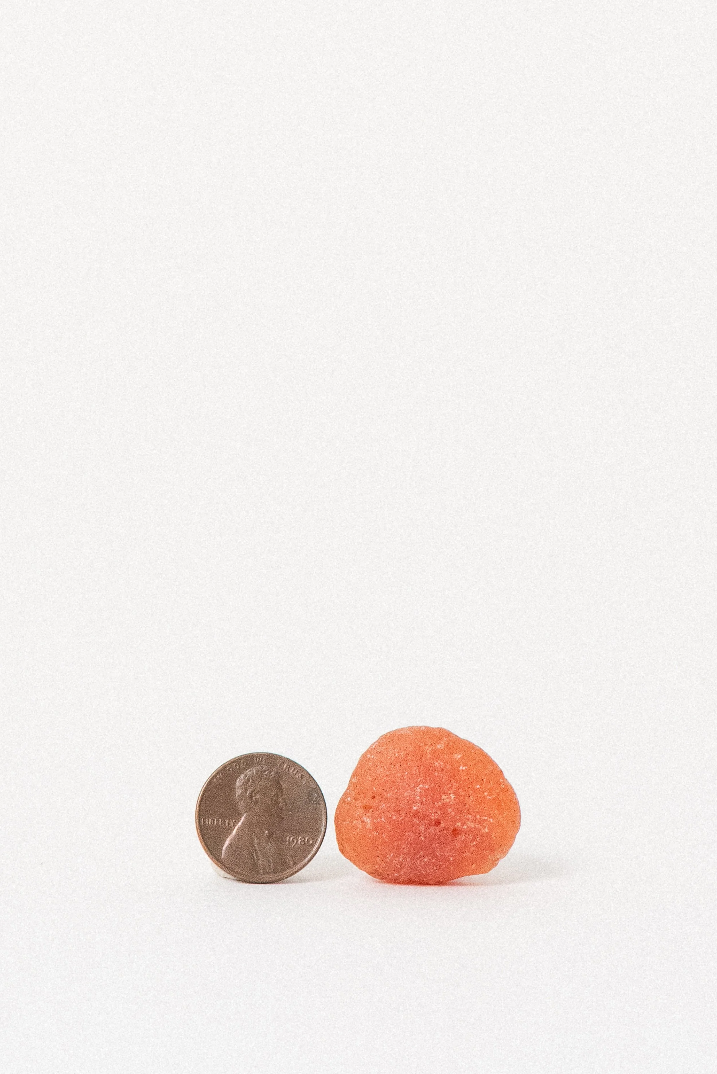 Vintage raw Carnelian stone from Africa shown beside a penny for scale