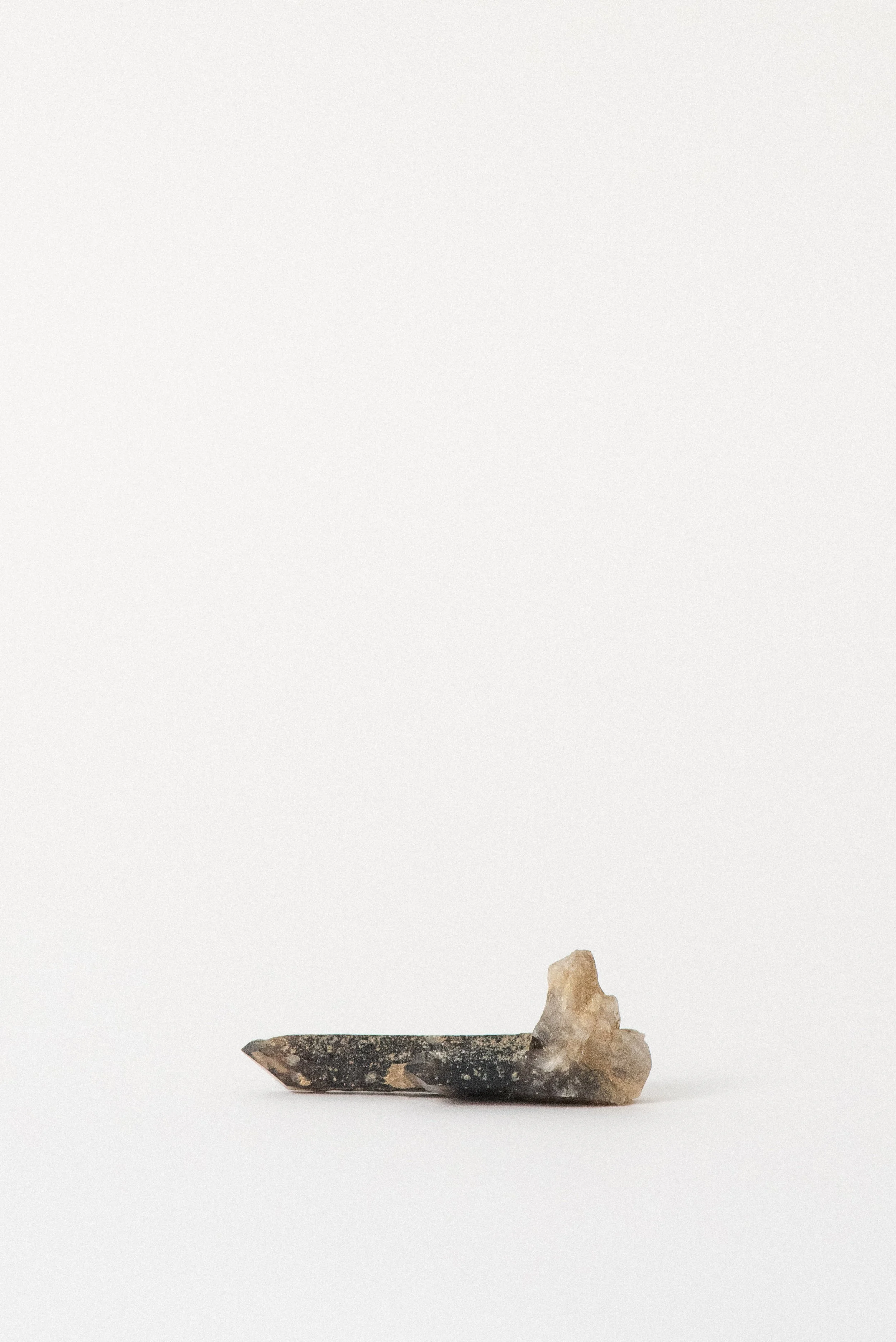 Smoky quartz crystal with natural base, elongated formation from Petersen Mountain region.