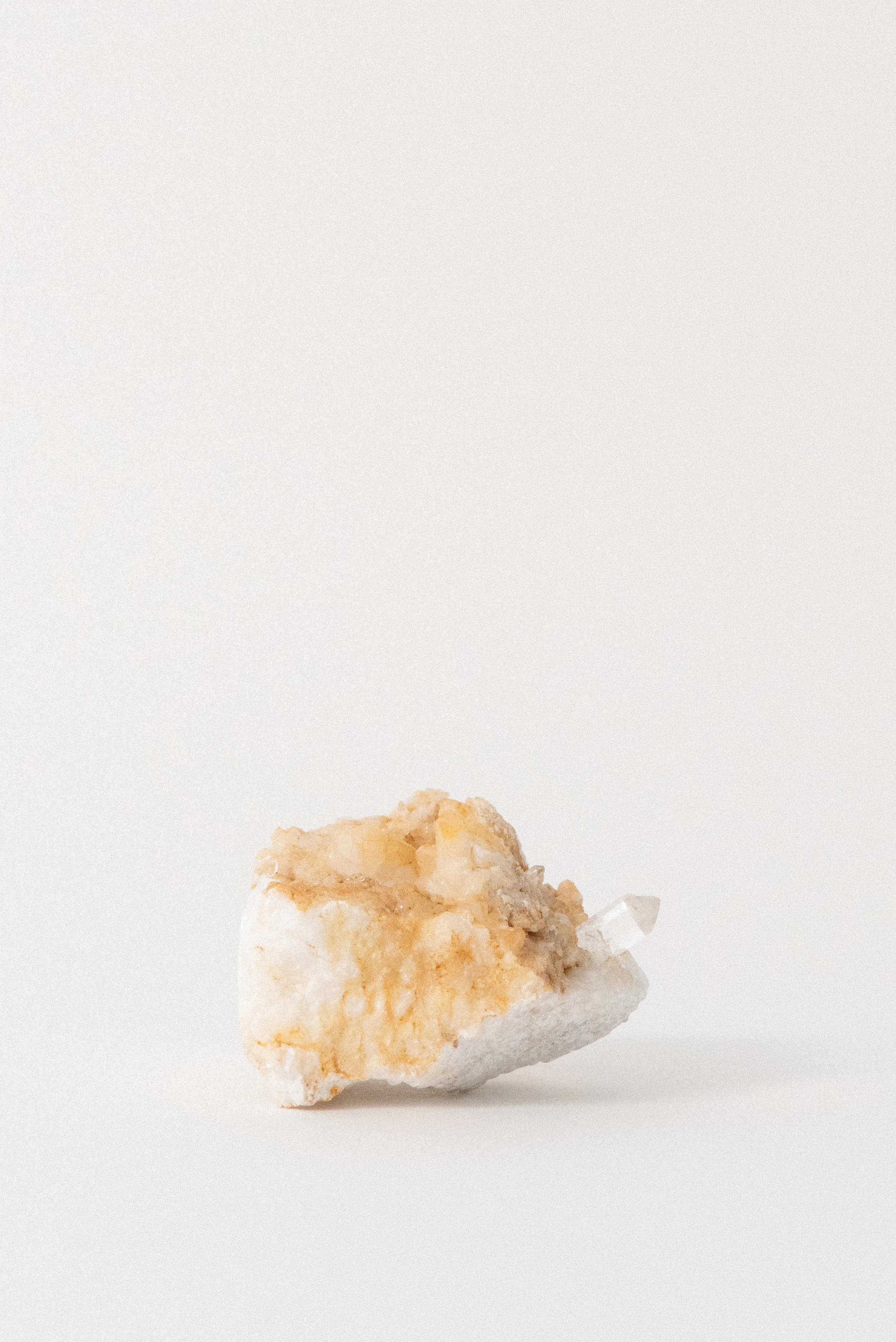 Horizontal view of quartz crystal on Carrara marble from La Facciata Quarry in Italy, highlighting crystal termination and layered matrix, photographed for Crystal Voyager.