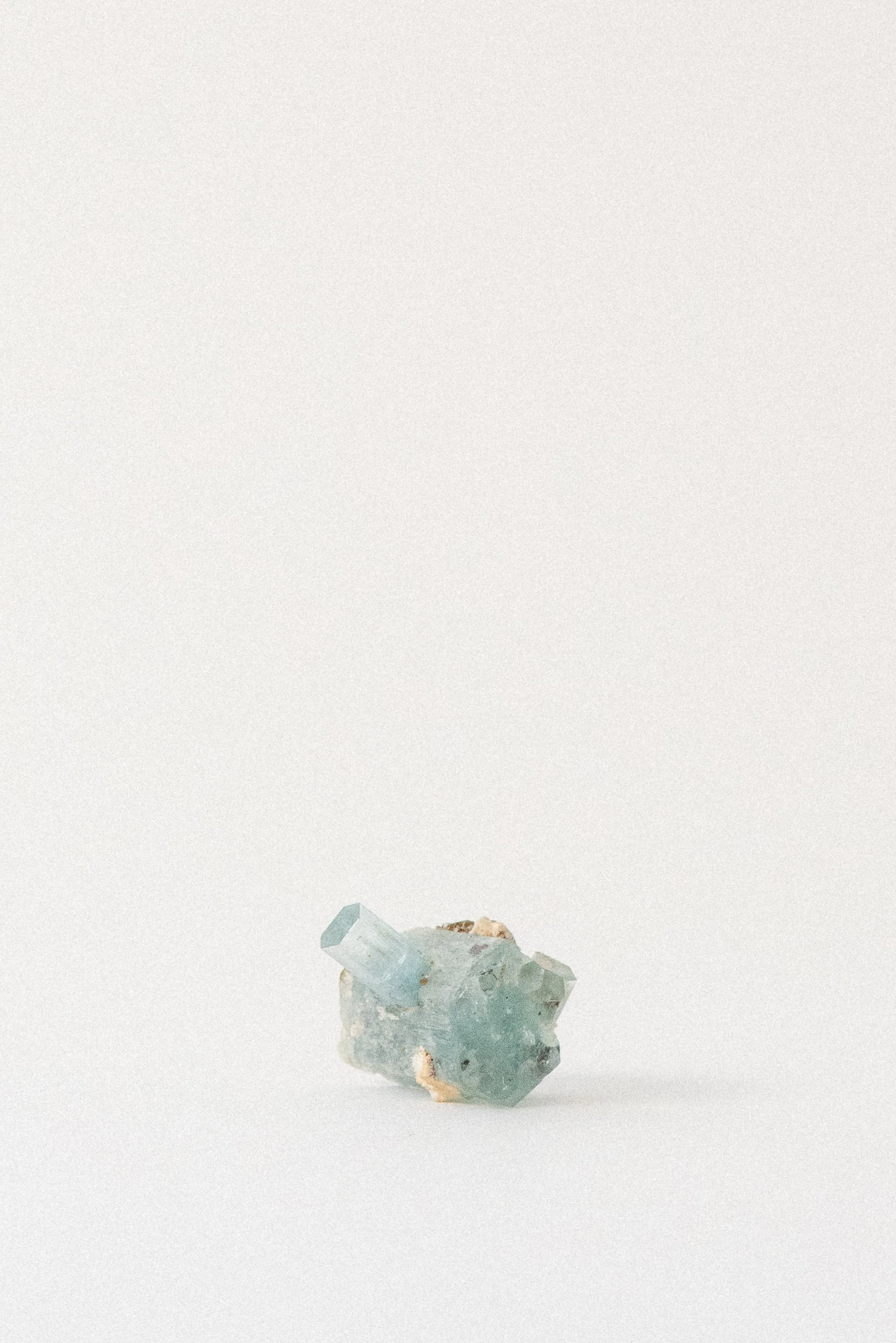 Aquamarine crystal from Erongo Mountain, Namibia, showing hexagonal growth and pale blue clarity on a white surface