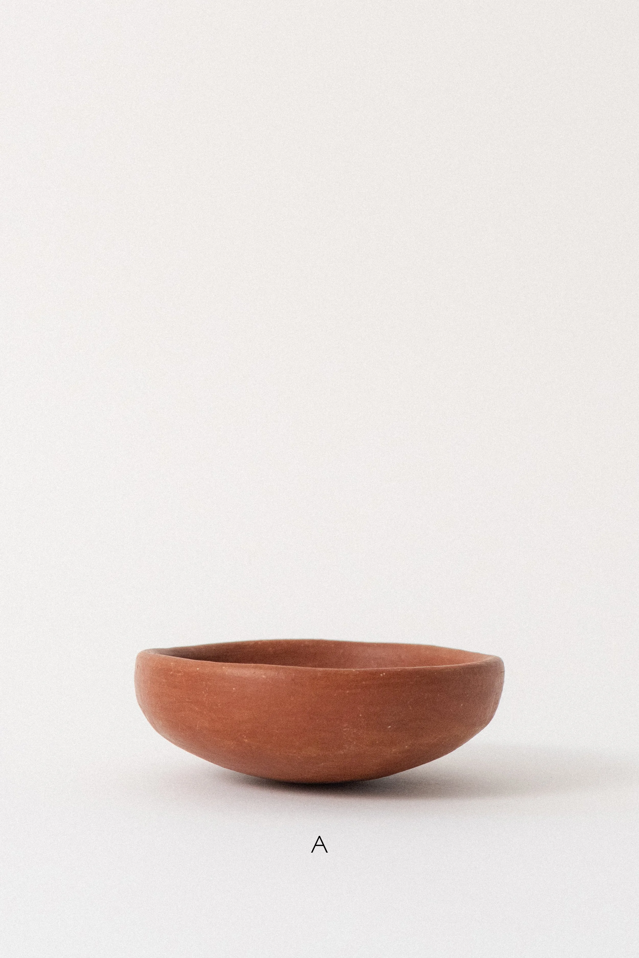 Single handmade barro rojo red clay bowl labeled A, crafted in Oaxaca, Mexico, displayed against a white background — rustic and versatile kitchenware.