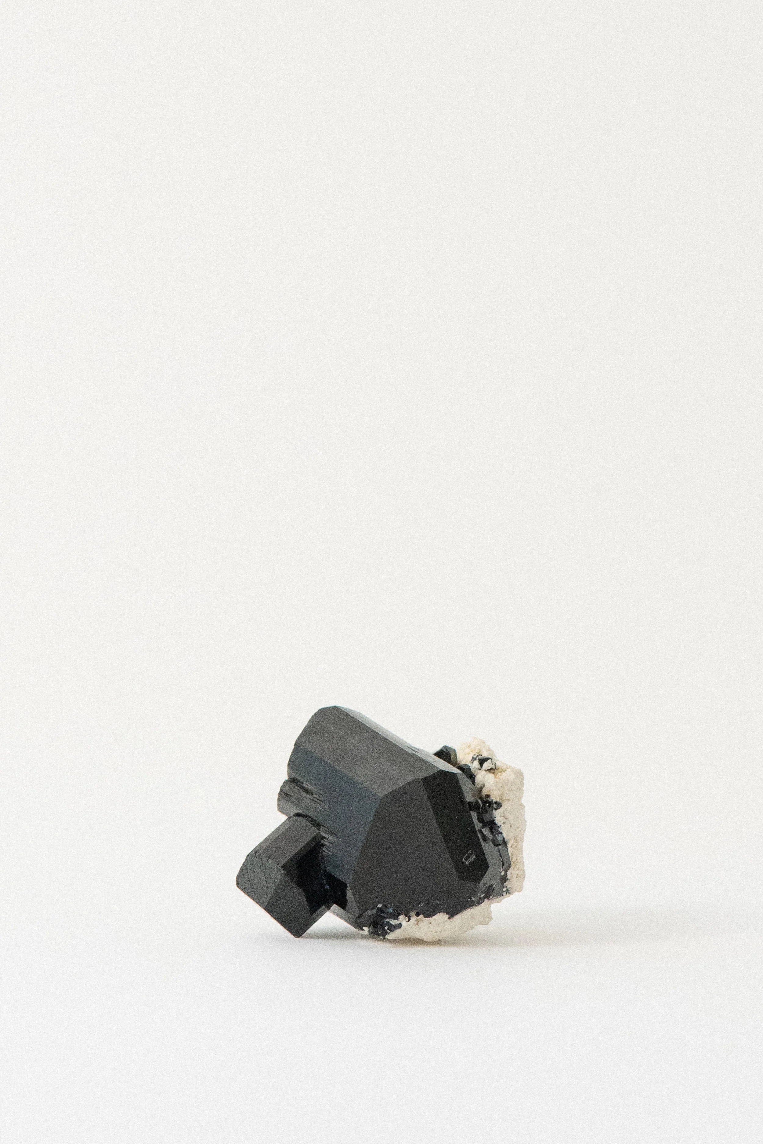 Black tourmaline crystal with cream matrix from Erongo Mountains, Namibia, front angle showing geometric terminations and natural texture