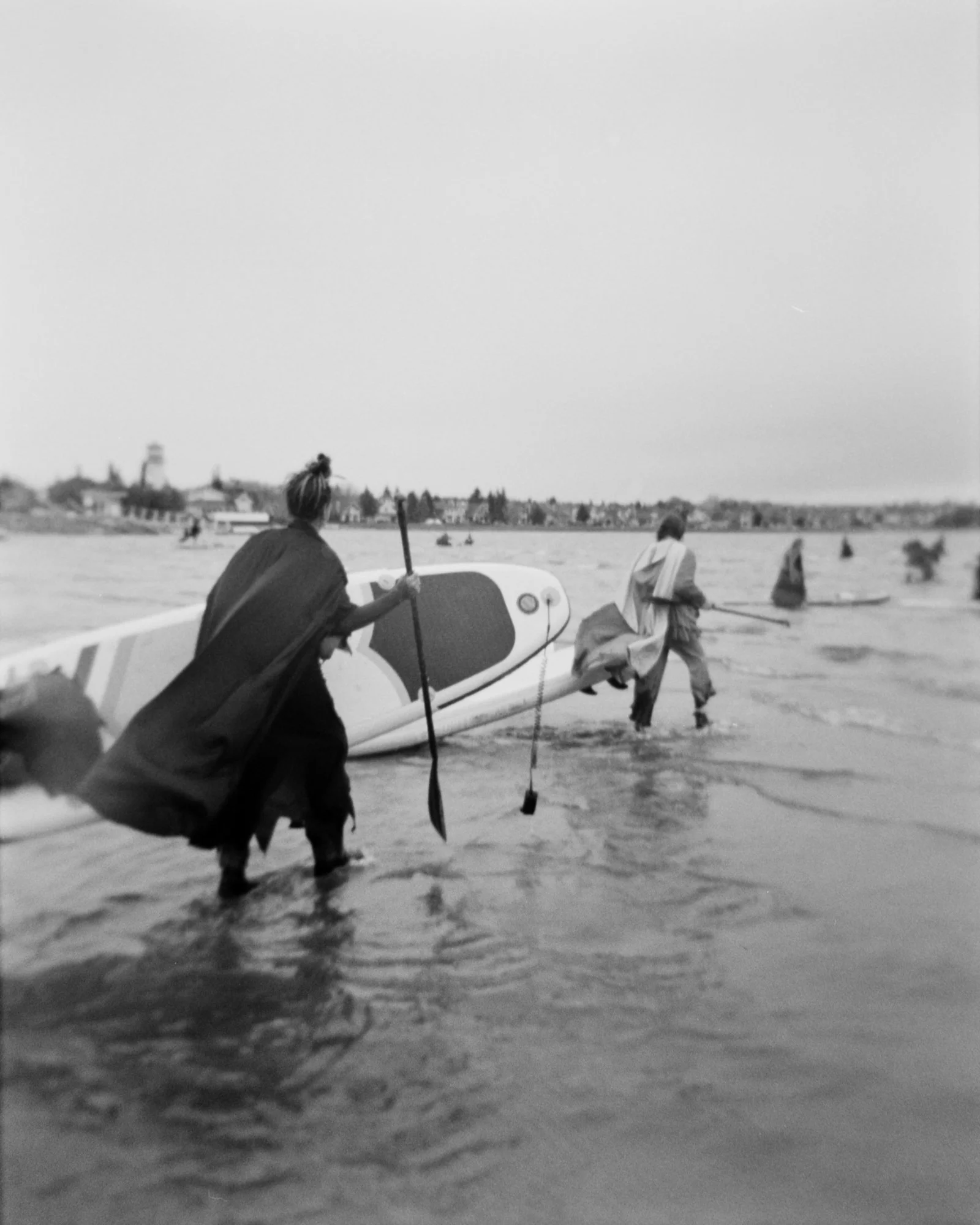 A coven of witches wade in a frigid lake for a group paddle in Sylvan Lake, Alberta.  Photographed with a Holga on Ilford HP5.