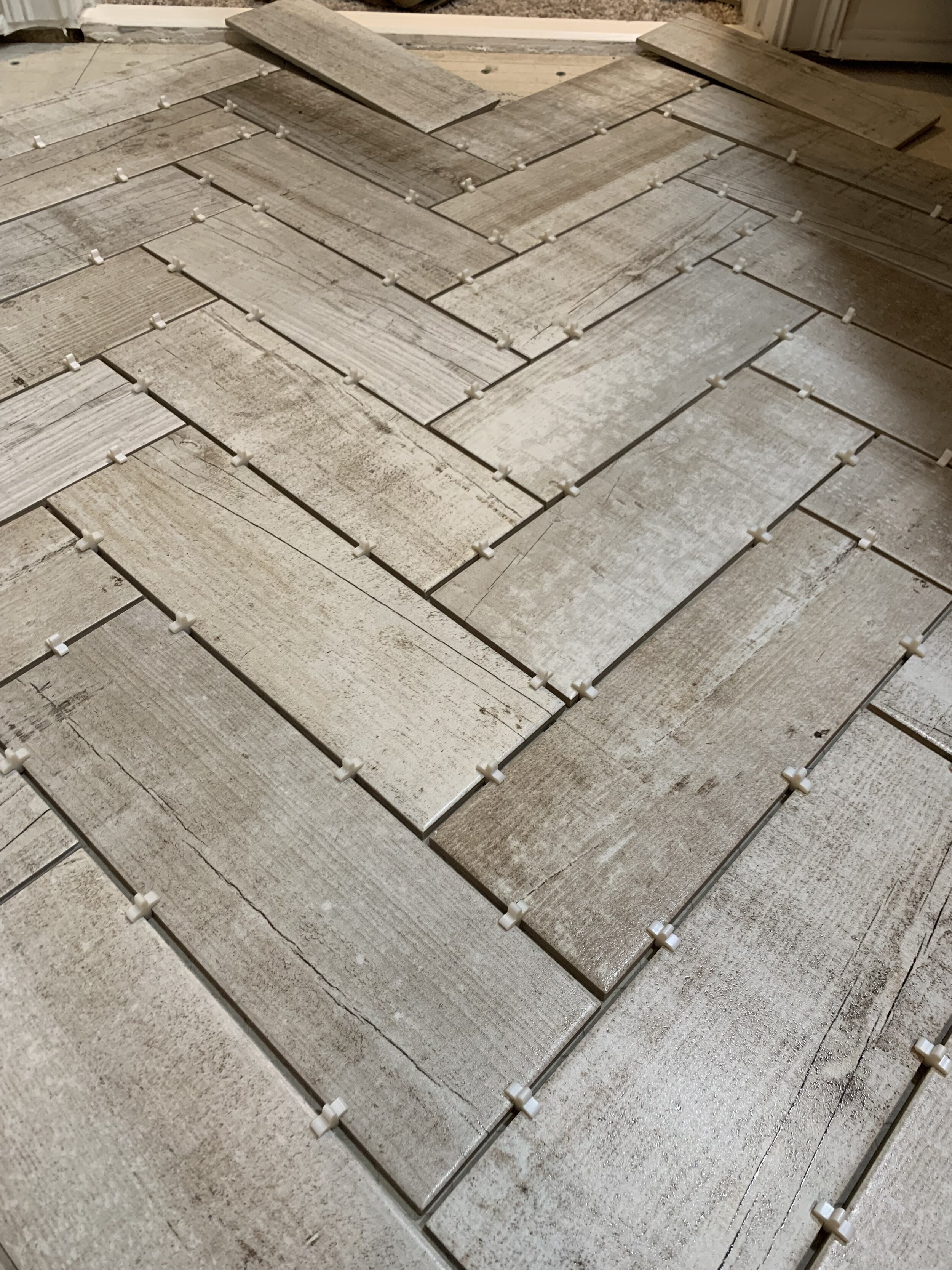 We dry fitting the tile first to practice the herringbone pattern and to see where we wanted to start the tile.